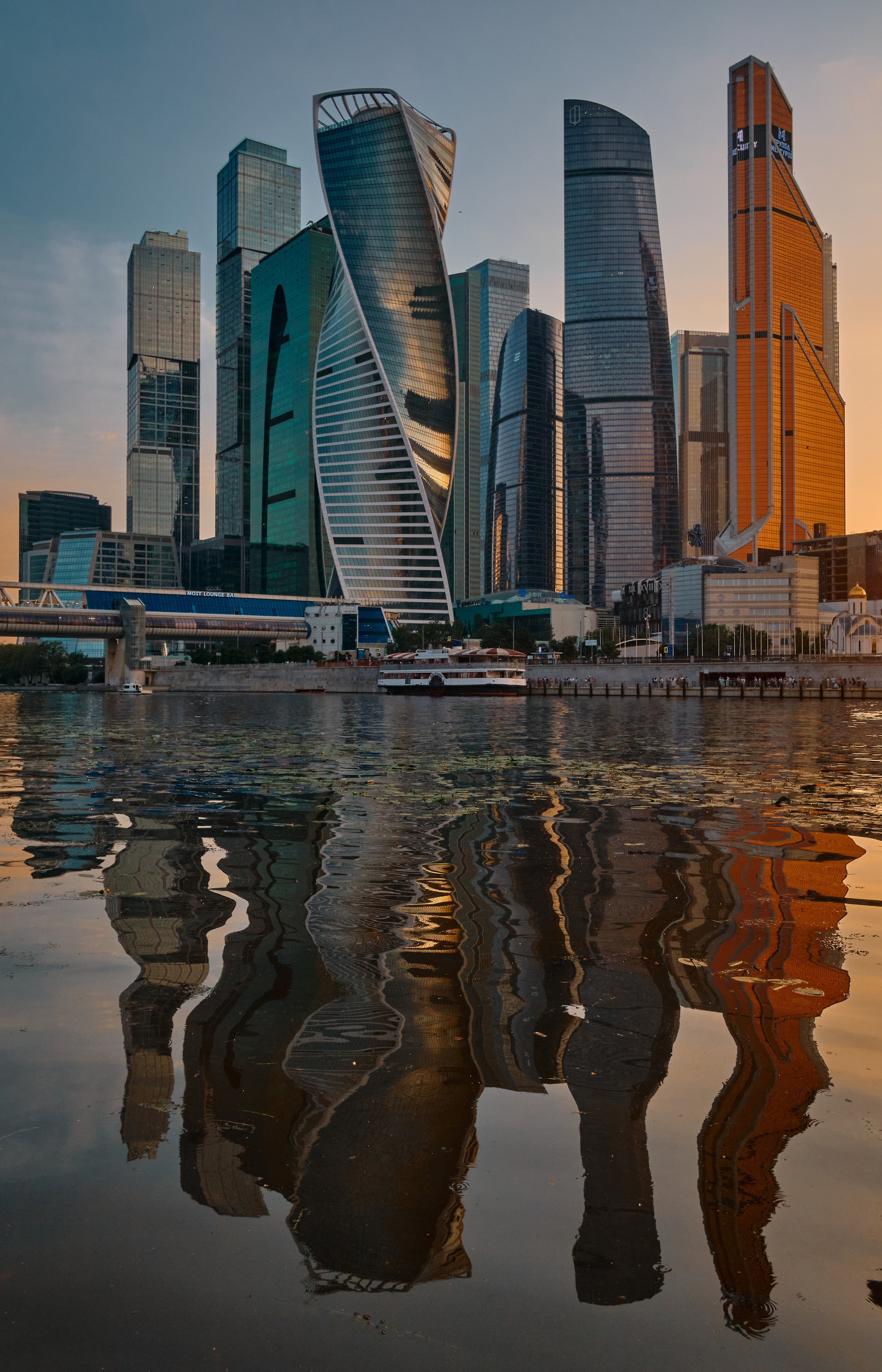 Ровные высотные здания Москва-Сити очень сильно преломляются в отражении Москва реки