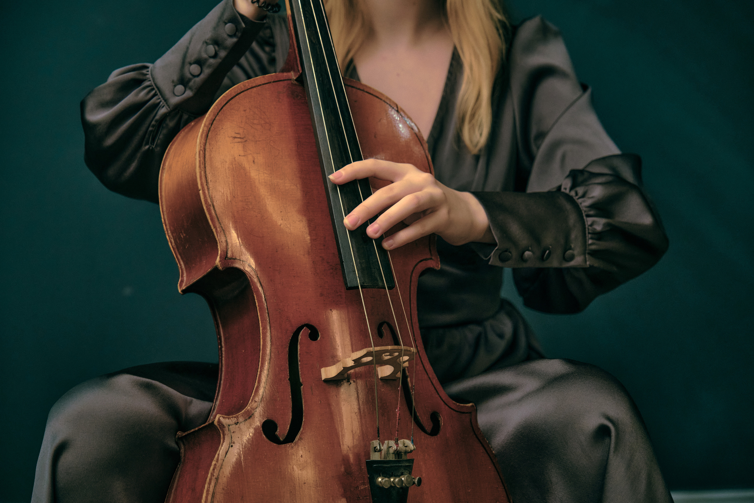 Виолончелистка играет на виолончели без смычка и без одной струны