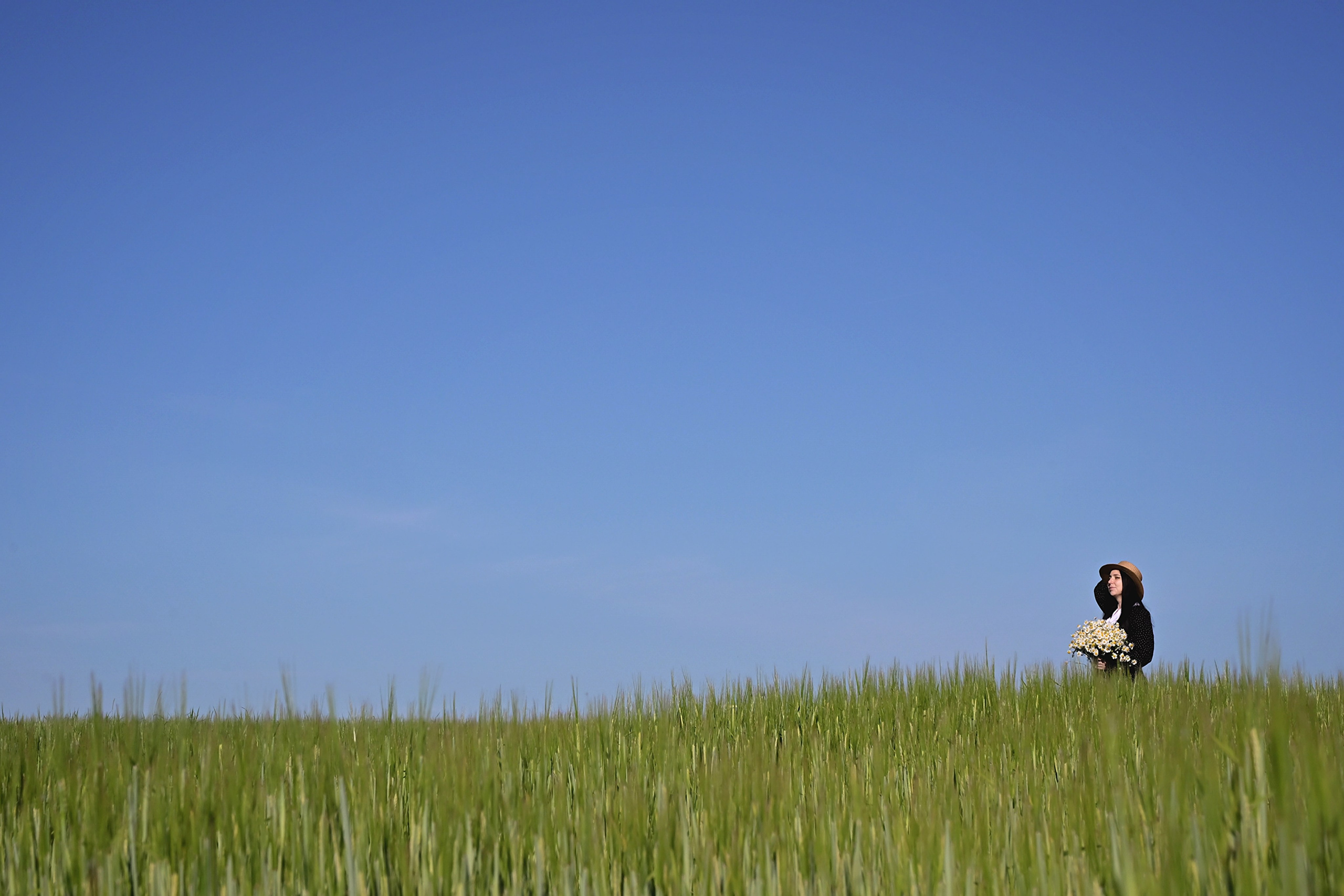 Девушка в поле с букетом ромашек