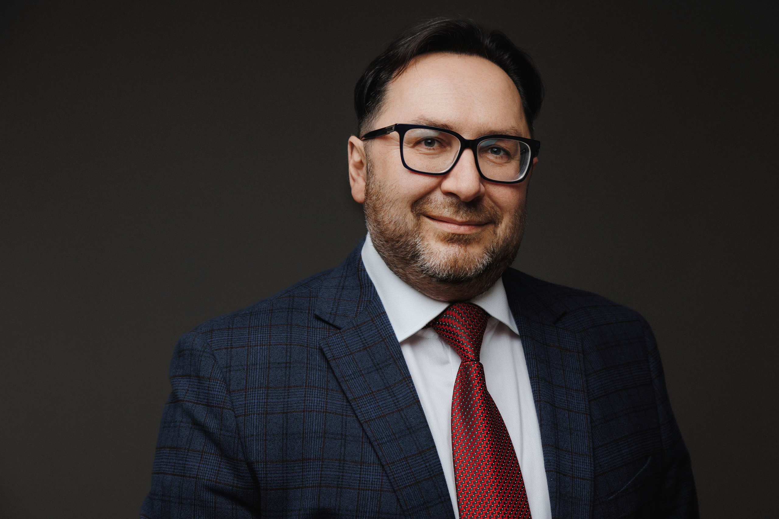 Контрастный деловой портрет мужчины на темном студийном фоне.