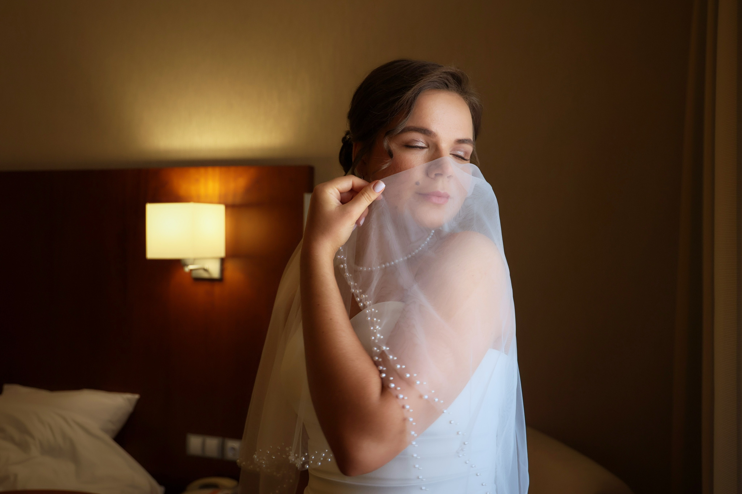 невеста прикрывает лицо фотой в гостинице Самары в отеле Холидей Ин