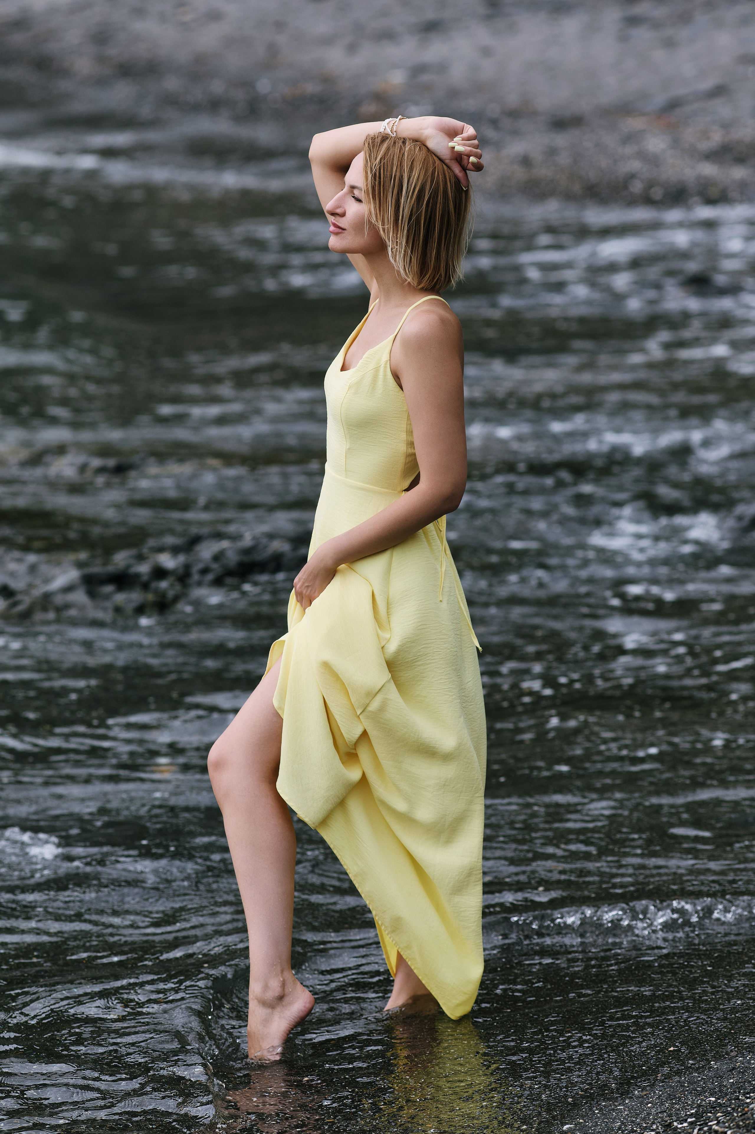 Морская фотосессия для женщины в жёлтом платье на пляже с чёрным песком в Находке