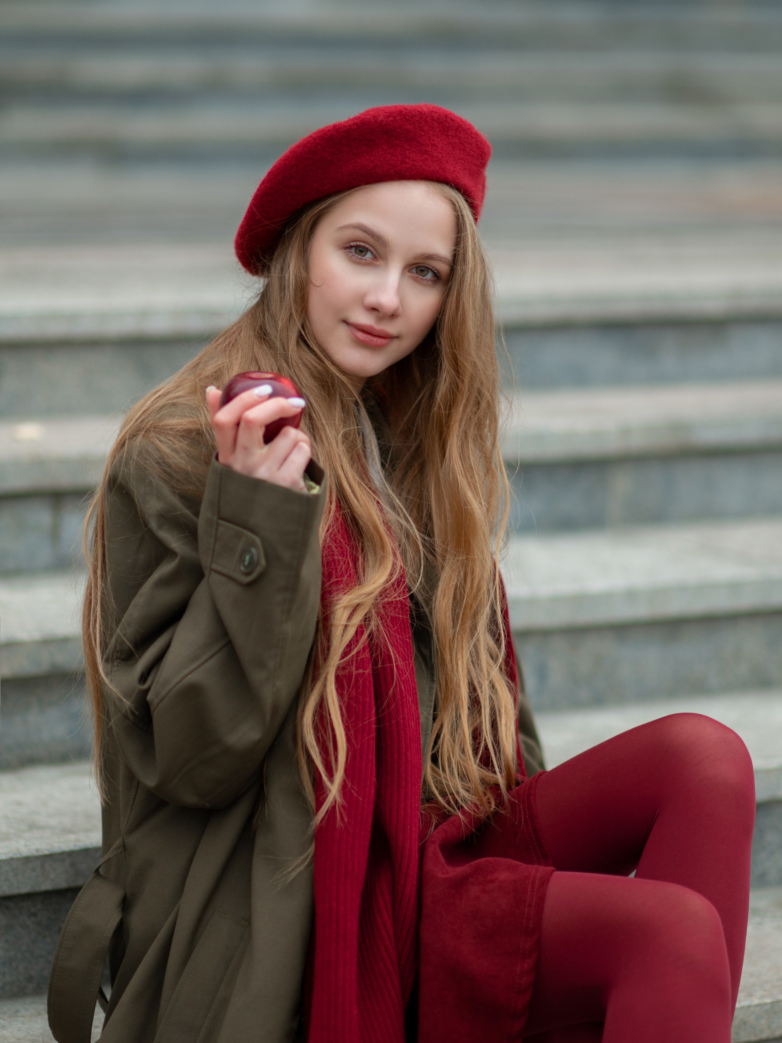 Фото девушки в пальто и в красном берете на ступеньках 