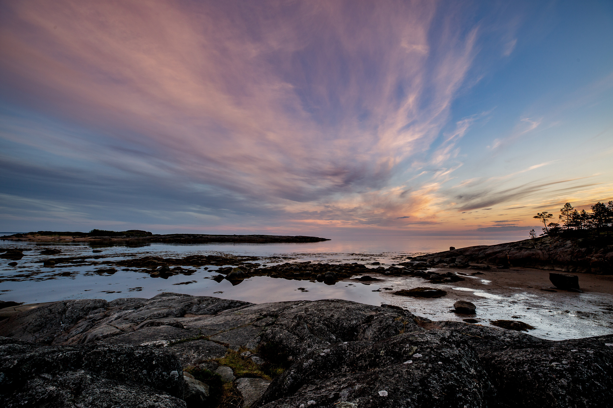 яркие облака окрашенные  закатом над островом Кий в Белом море