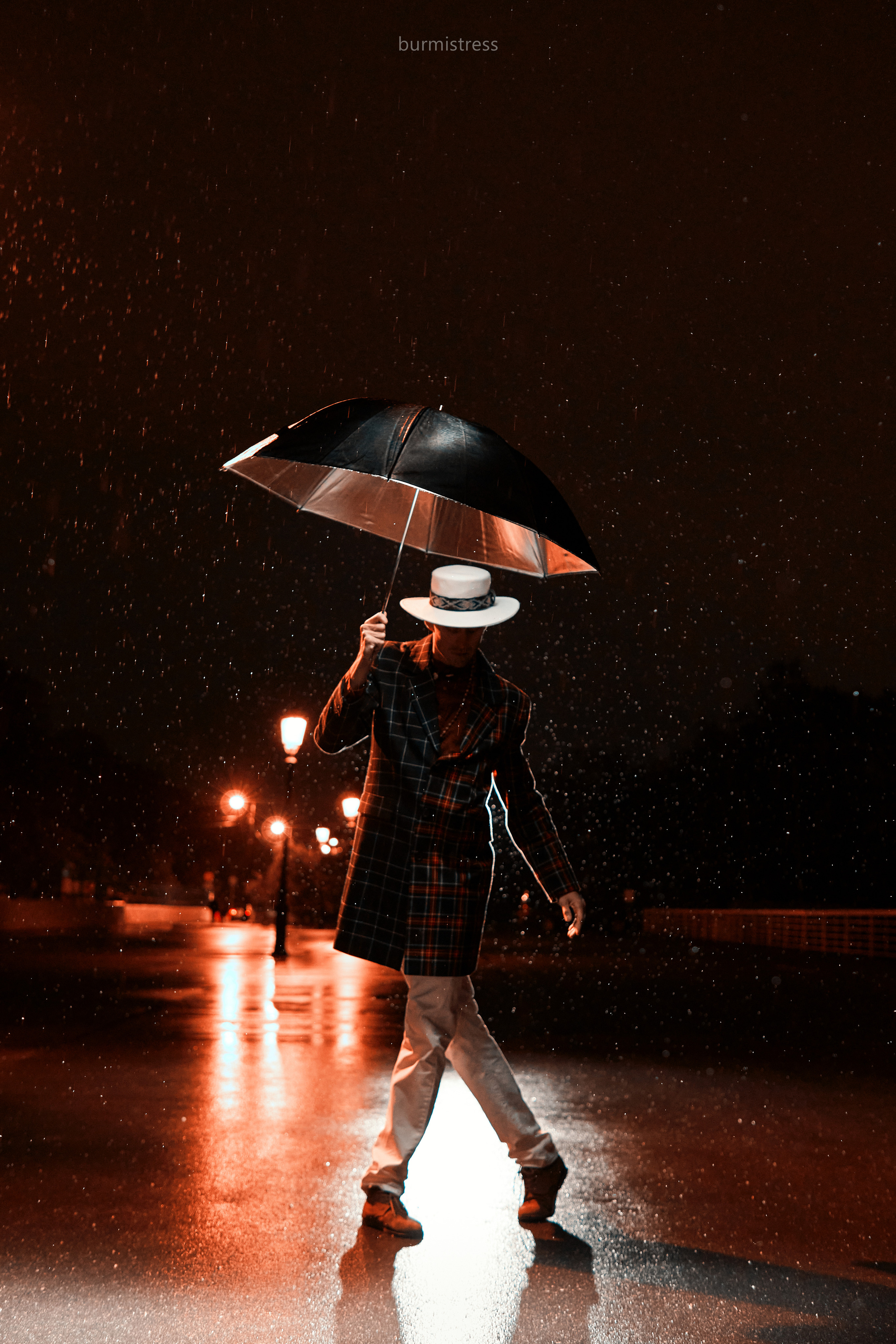 стильная фотосессия со вспышкой мужчины танцора ночью в Санкт-Петербурге в образе с белой шляпой на фоне фонарей с зонтом под дождем в стиле кино или мюзикла, стробизм ночью