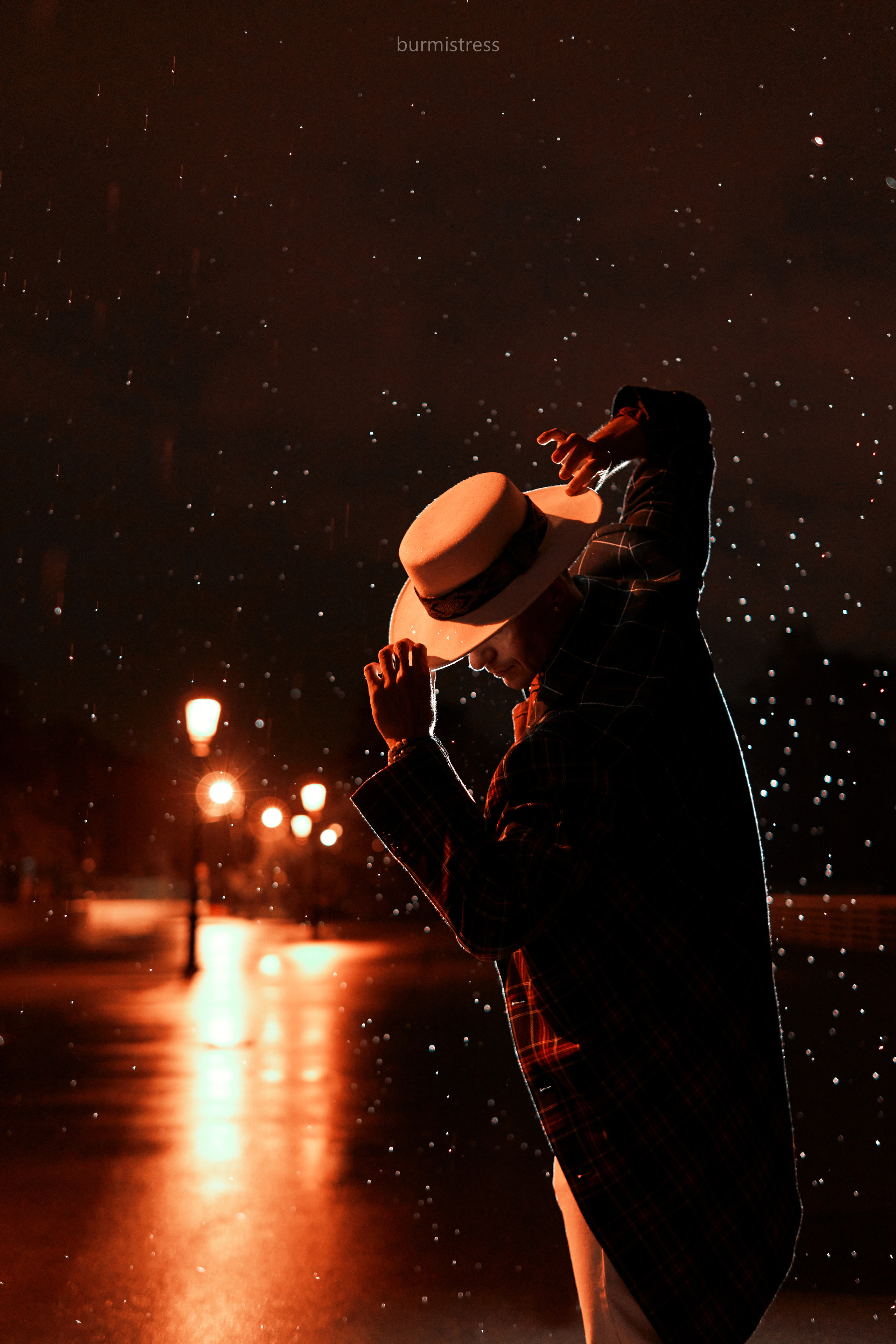 стильная фотосессия со вспышкой мужчины танцора ночью в Санкт-Петербурге в образе с белой шляпой на фоне фонарей под дождем в стиле кино или мюзикла, стробизм ночью