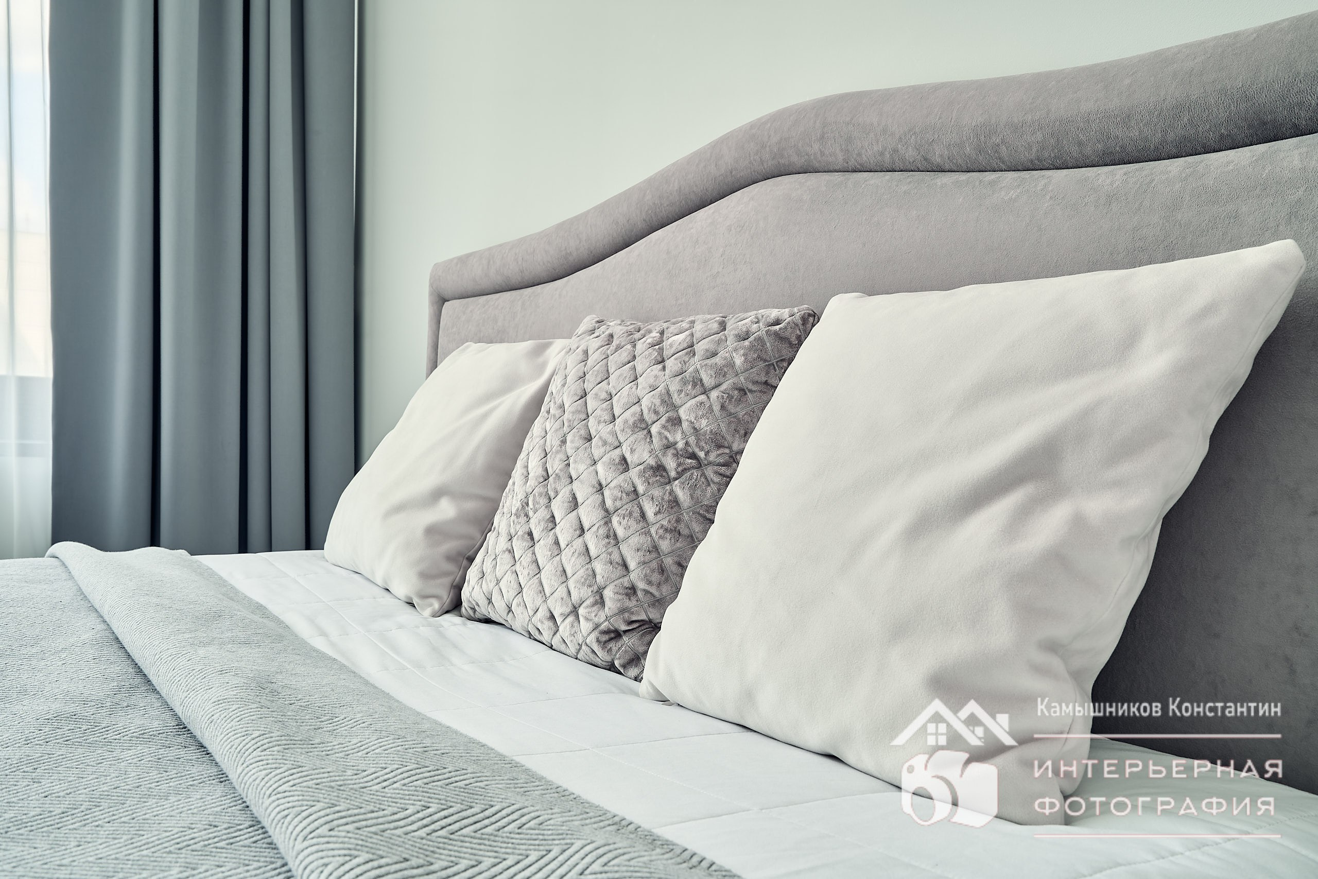 Интерьерное фото с подушками на широкой двуспальной кровати в квартире в ЖК бизнес-класса в Москве, крупный план