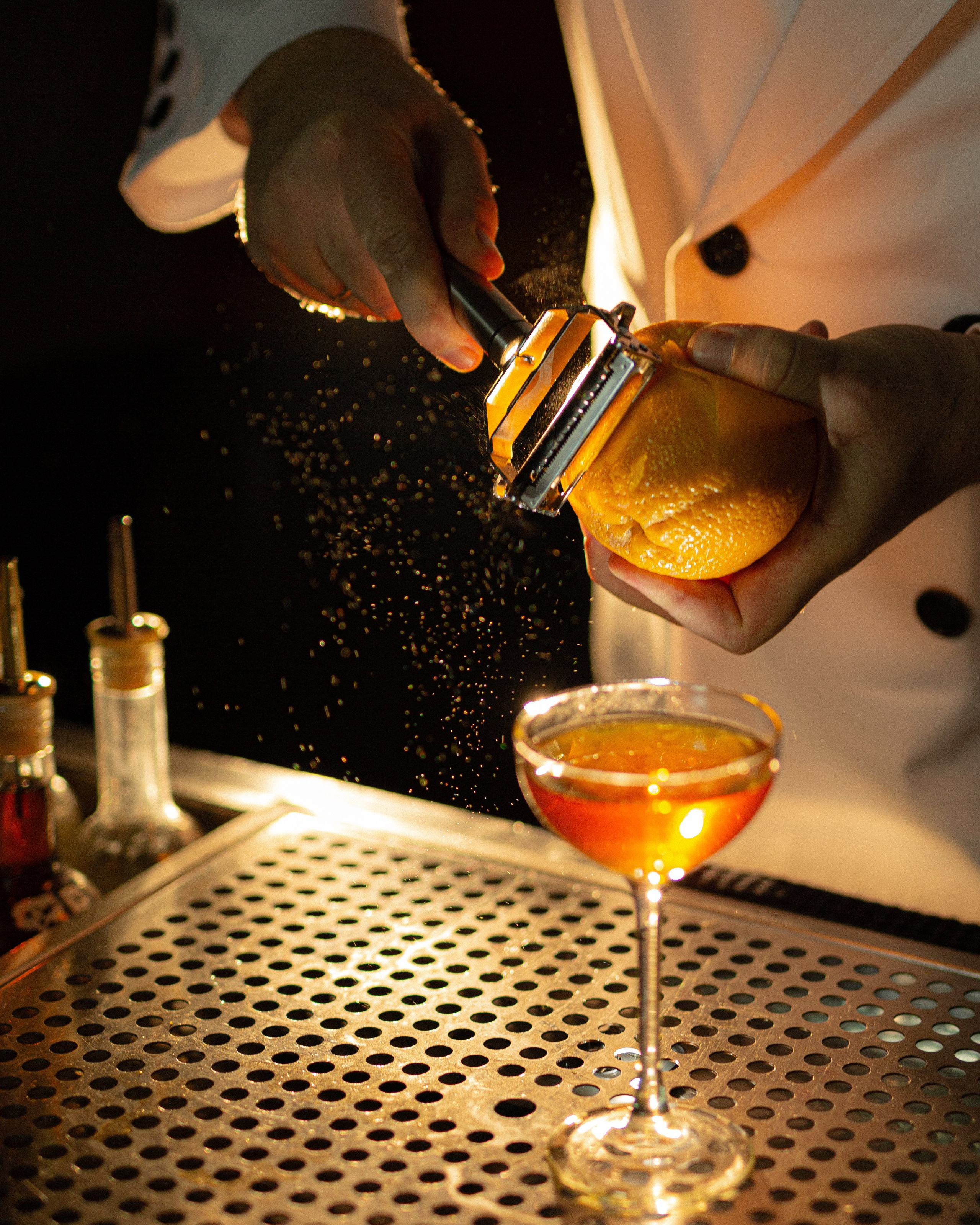 бармен готовит напиток: налив, лёд, цитрусы, детальная фуд-фотография
