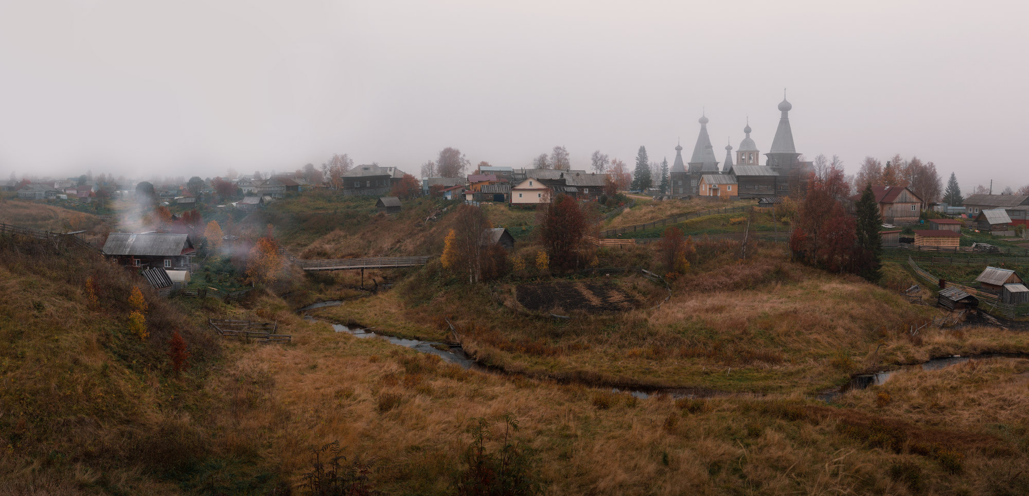Панорамный вид на северную деревевню. Из трубы идёт дым. 