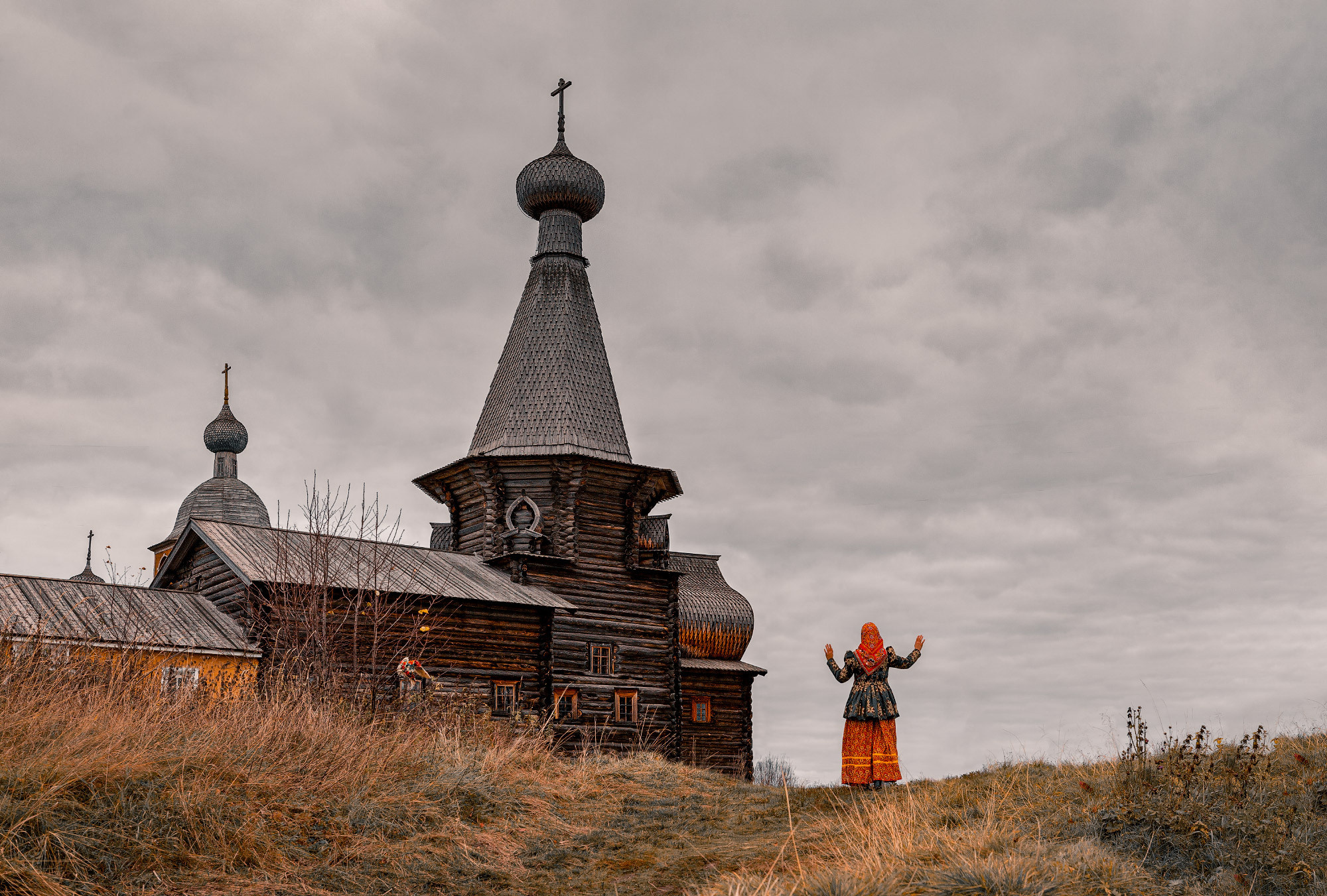Девушка в стариной одежде у Никольский церкви в поморское селе. 