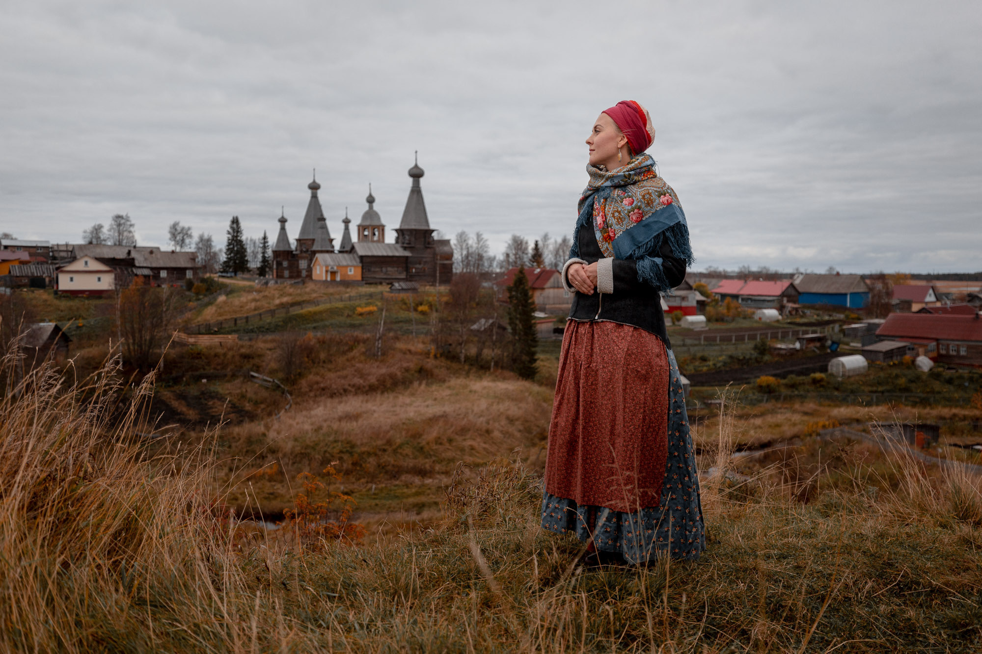 Женщина в поморском наряде стоит на холме Шоломье села Ненокса. 