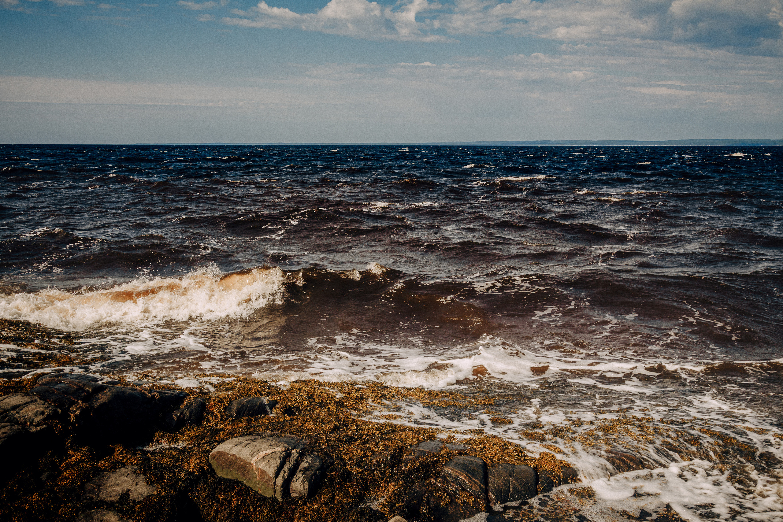 Морские волны бьют о каменистый берег острова. 