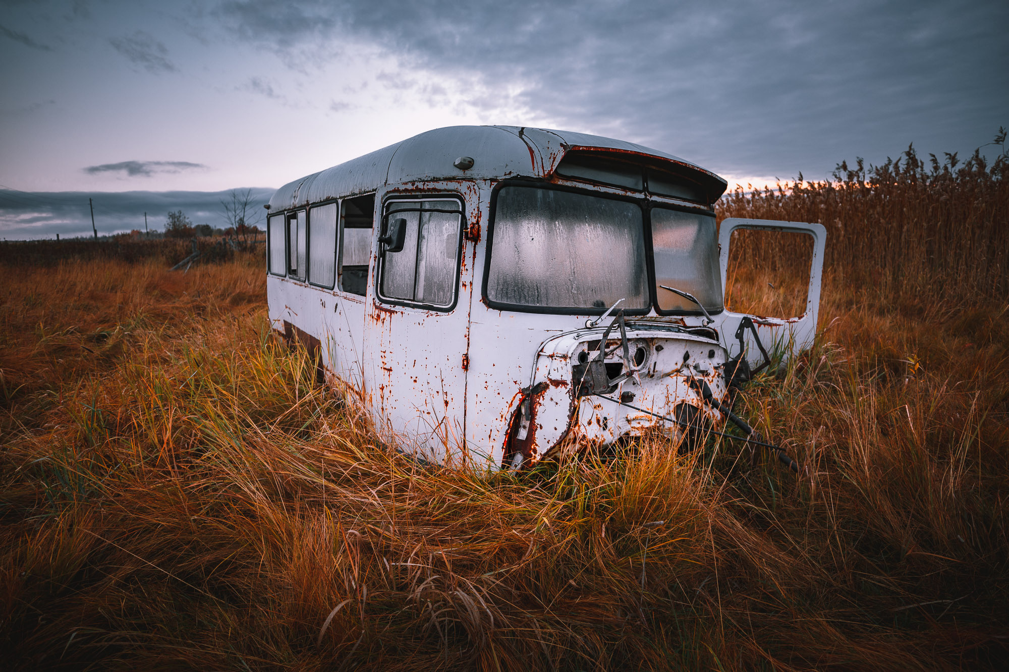 Старый заброшенный советский автобус в поле. 