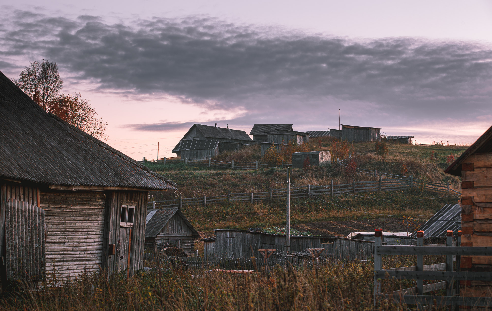 Деревенские дома под пасмурный вечерним небом. 