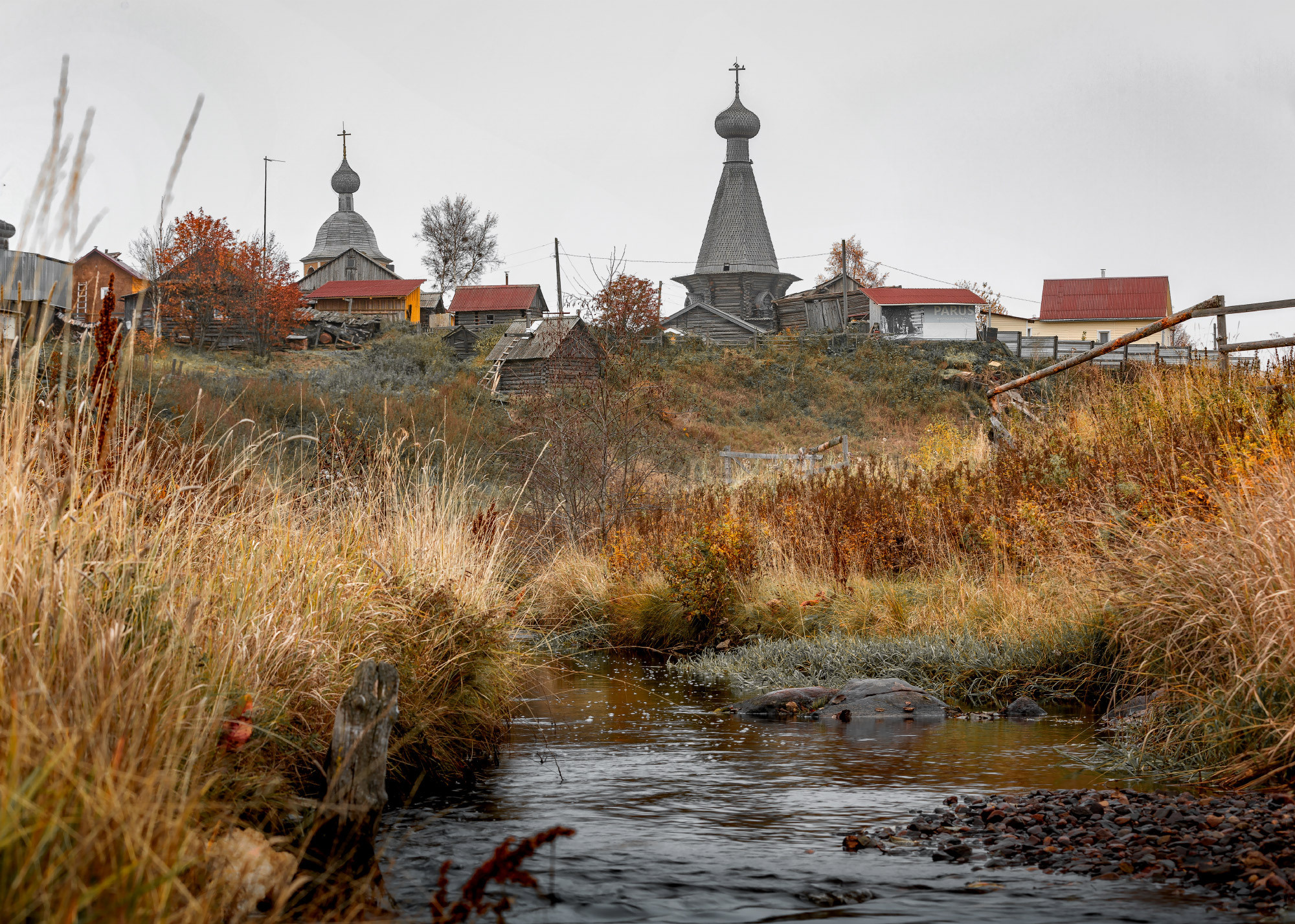 На переднем плане речка, на заднем поморское село. 