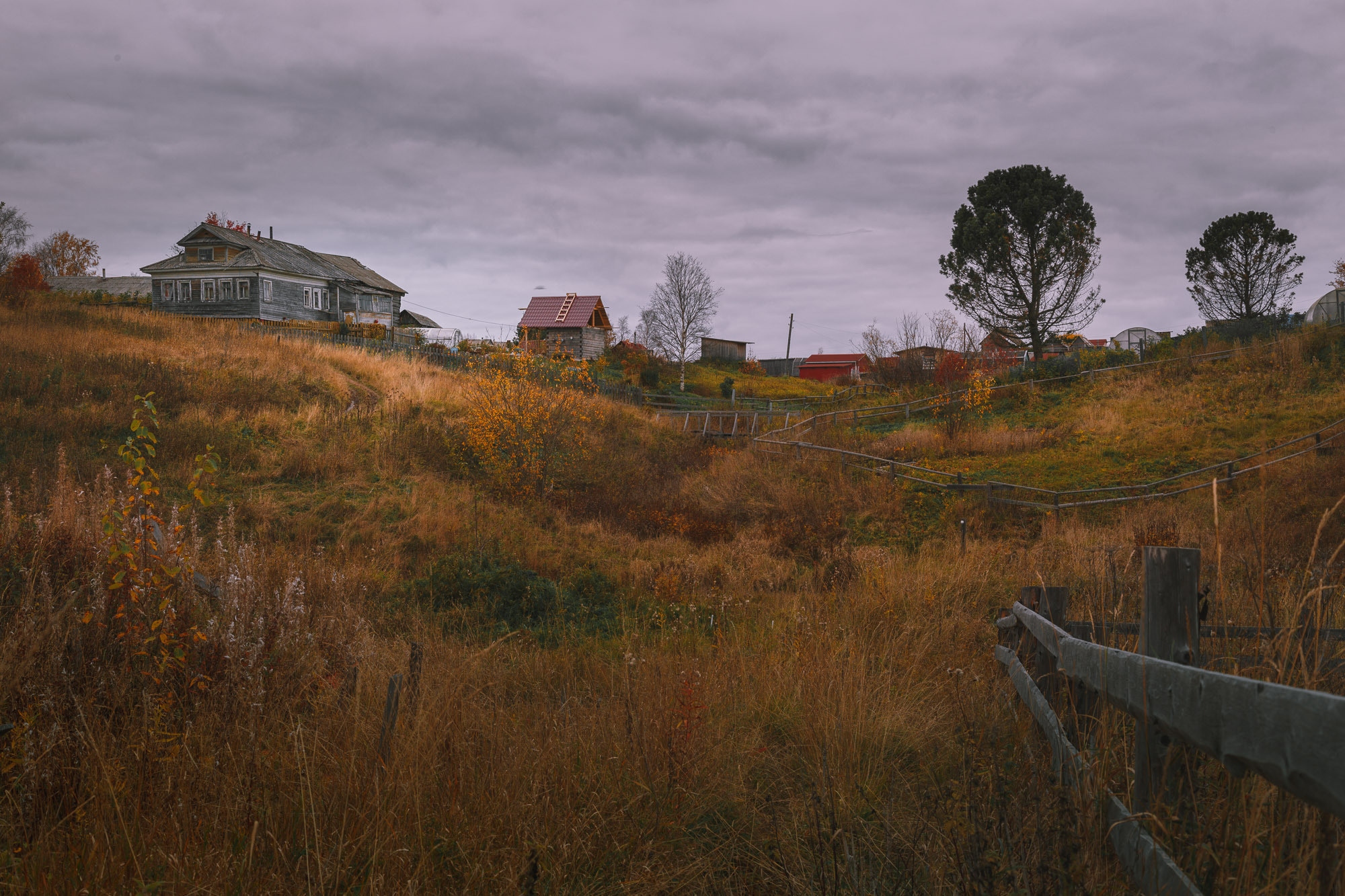 Грунтовая дорога, дом, забор, пасмурно небо. 