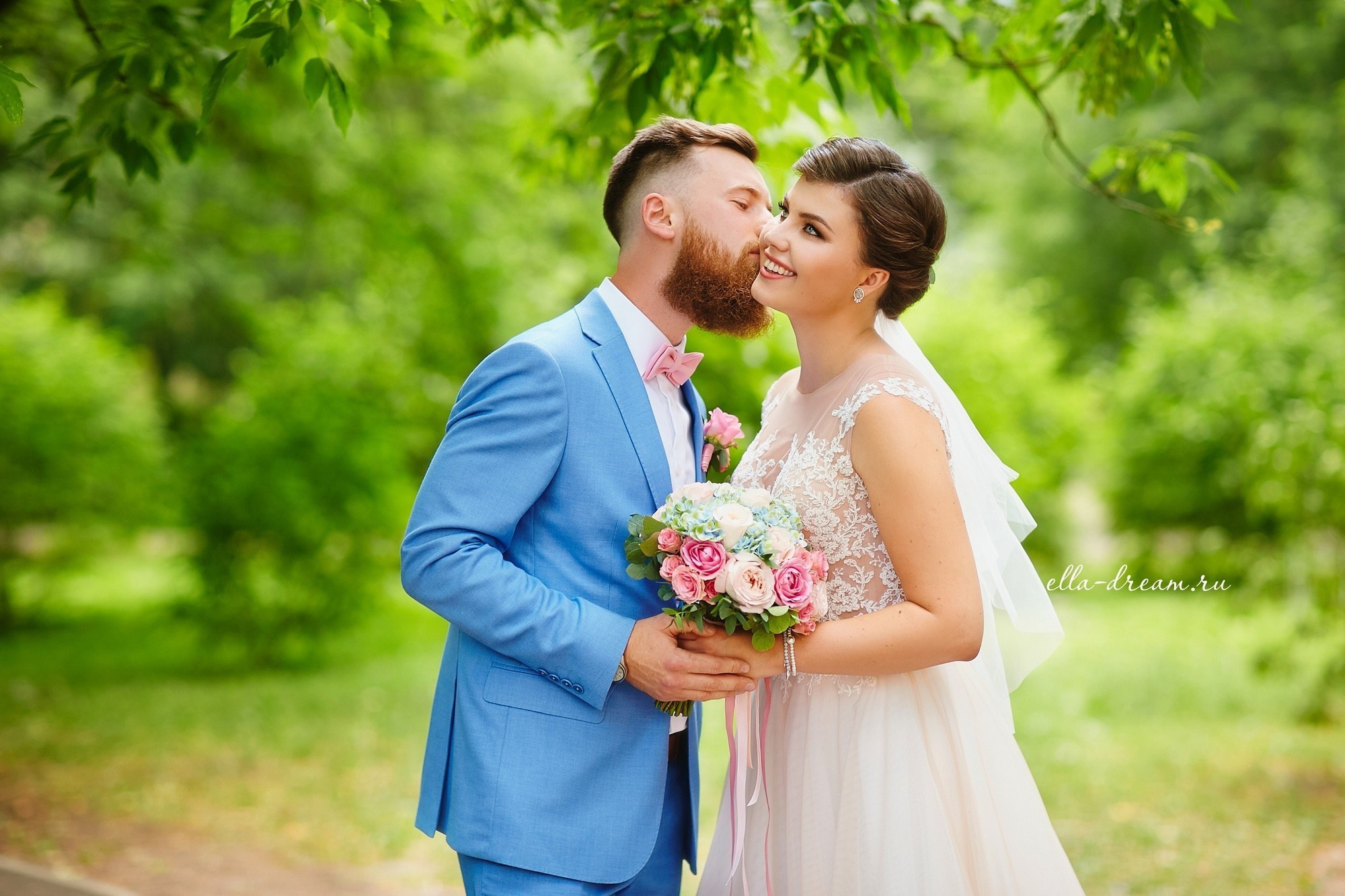 сочная  яркая солнечная фотография летней свадьбы жениха в голубом костюме и  красивой стильной невесты