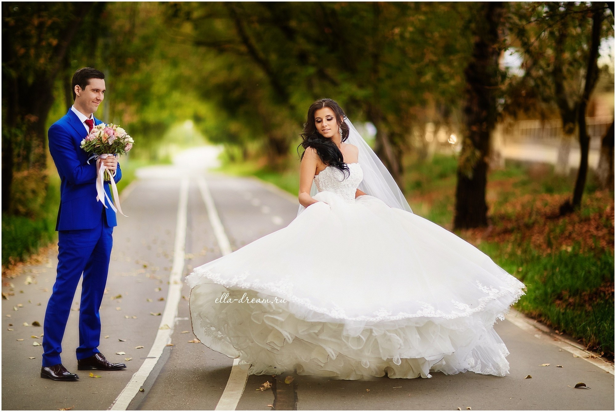 невеста в белом пышном платье крутится перед довольным женихом