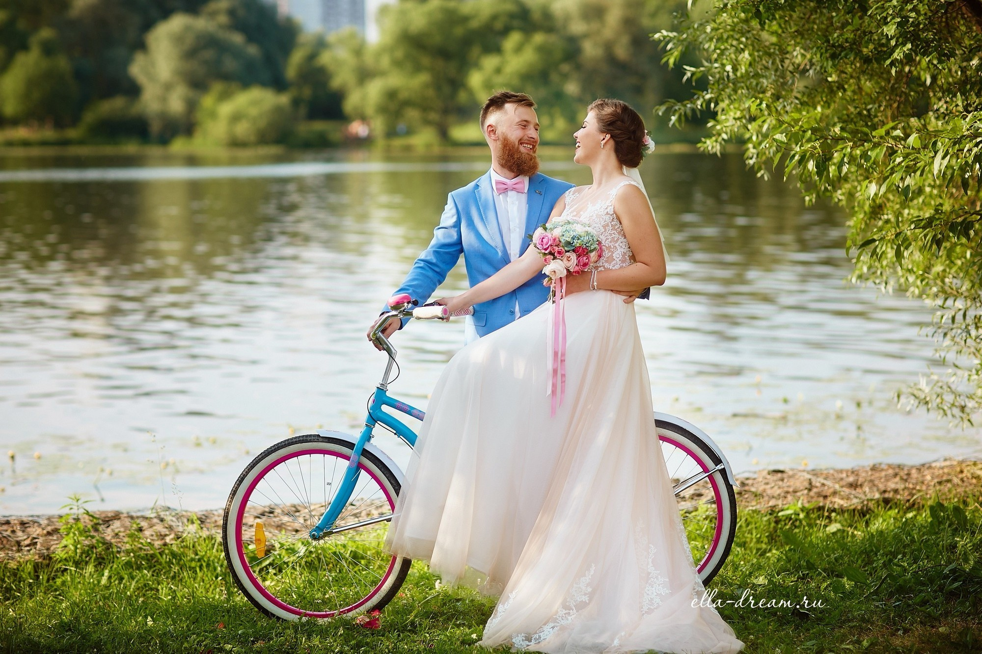 Жених и невеста на велосипеде на фоне реки. Велосипед на свадьбе. Свадебный голубой  велосипед 