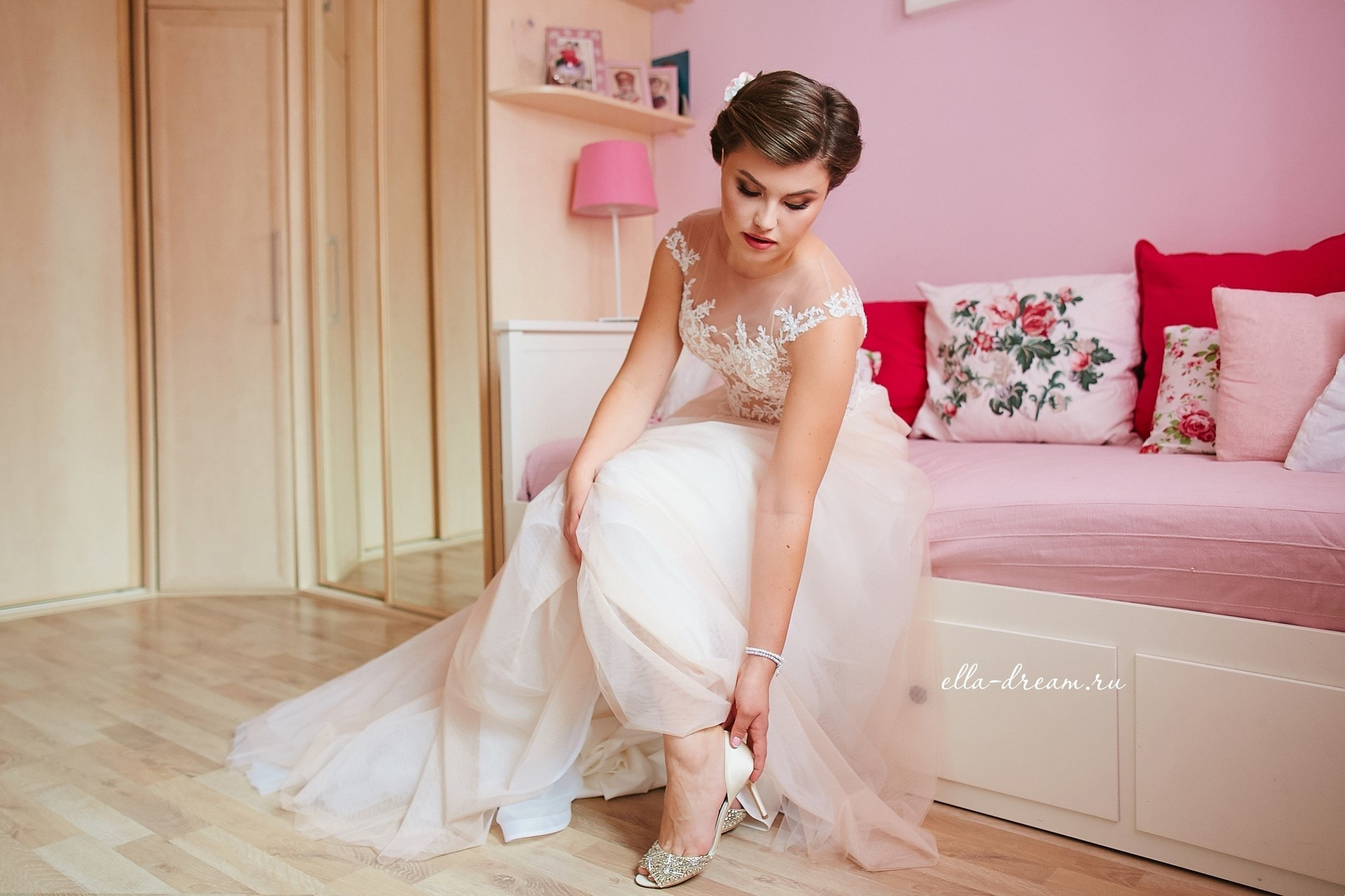 Невеста надевает туфли в розовой комнате pin up