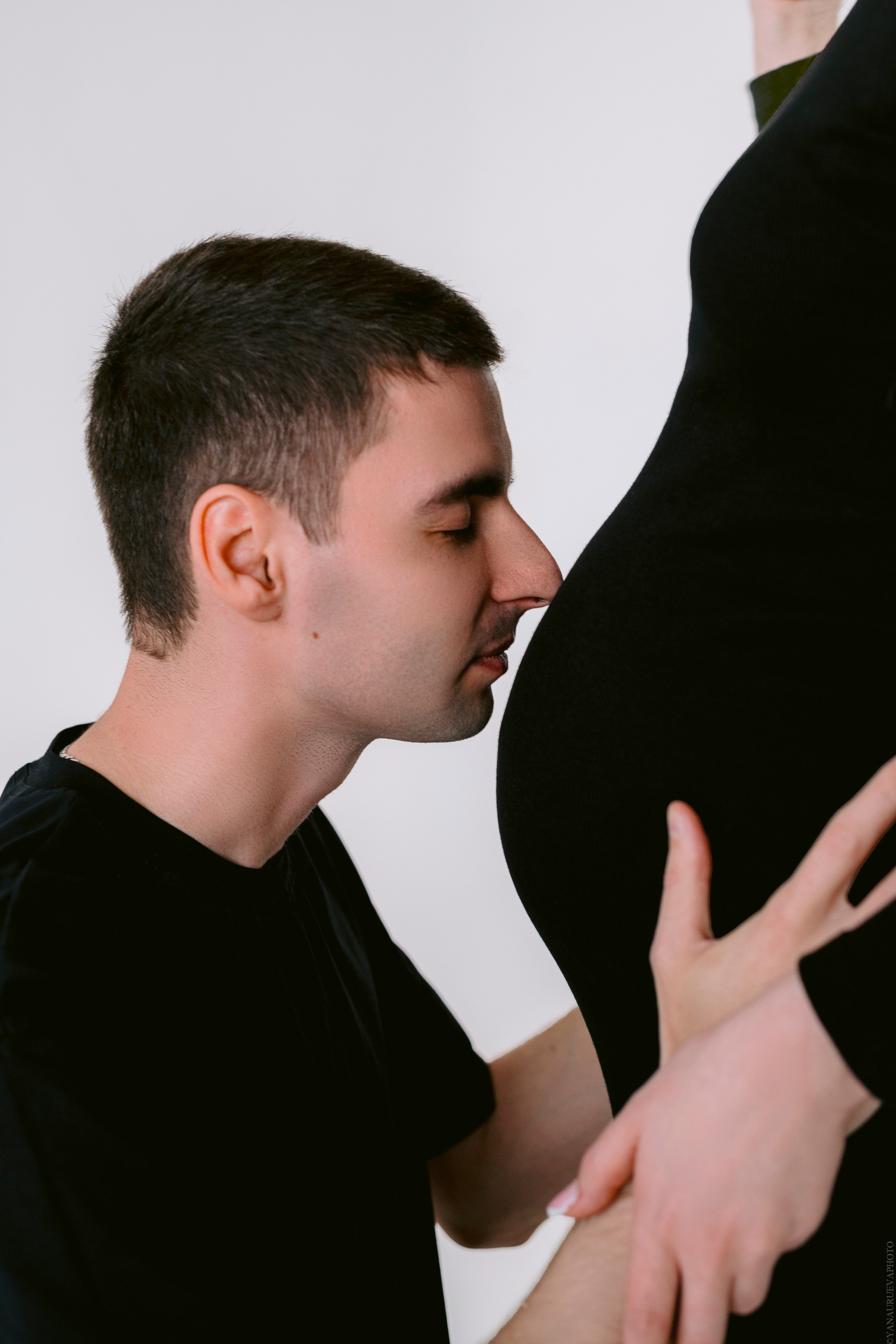 отец целует беременный живот