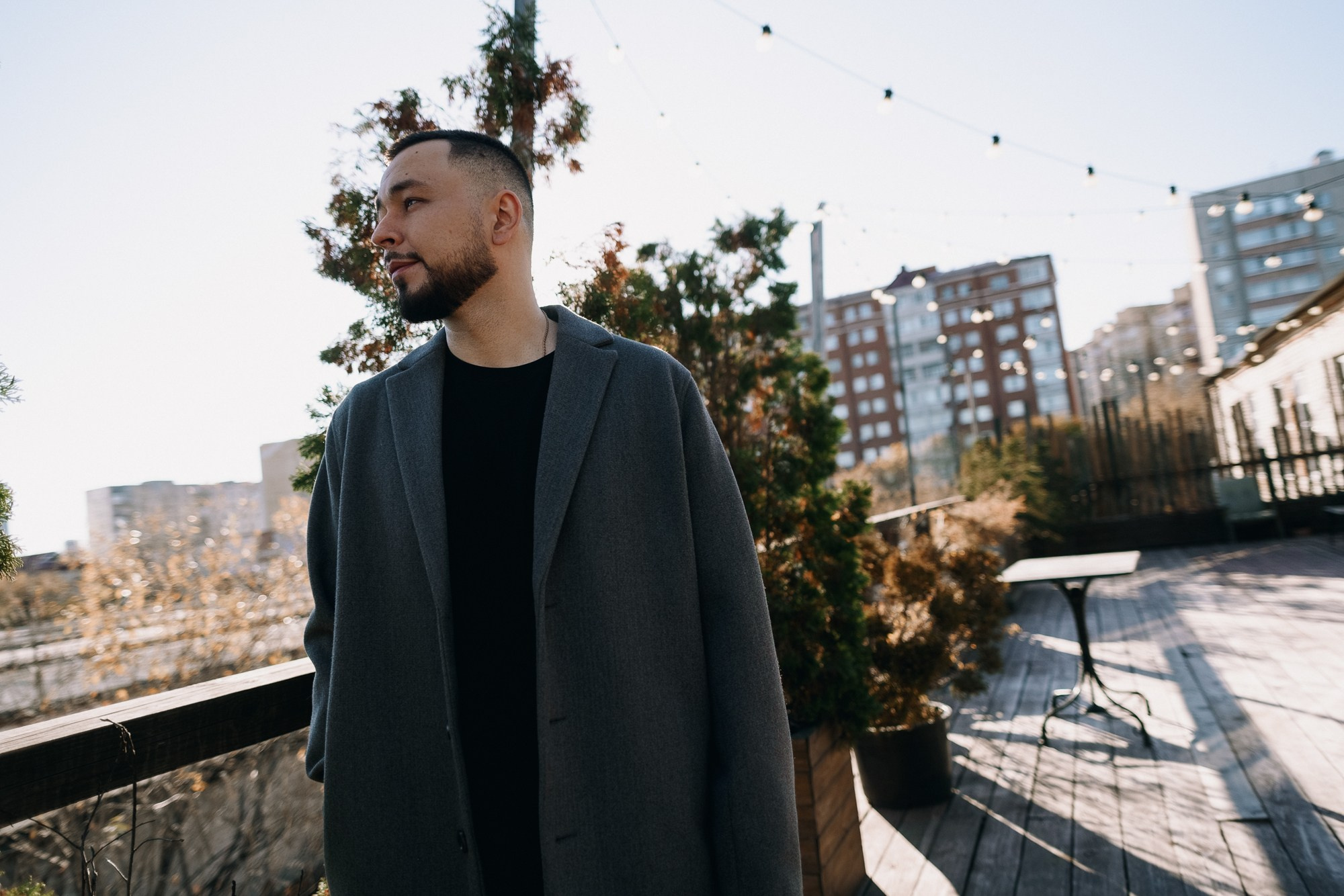 Уверенный мужской образ в пальто, профессиональная съемка в Тюмени, работа с ракурсами и глубокими тенями в портрете