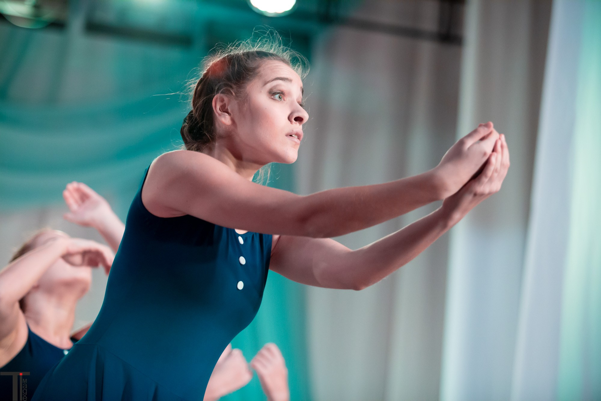 Девушка в синем платье исполняет танец на конкурсе