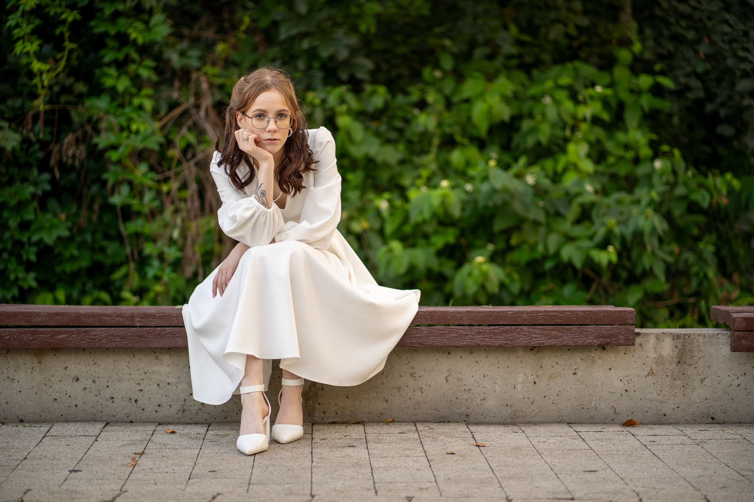 Невеста позирует на скамейке