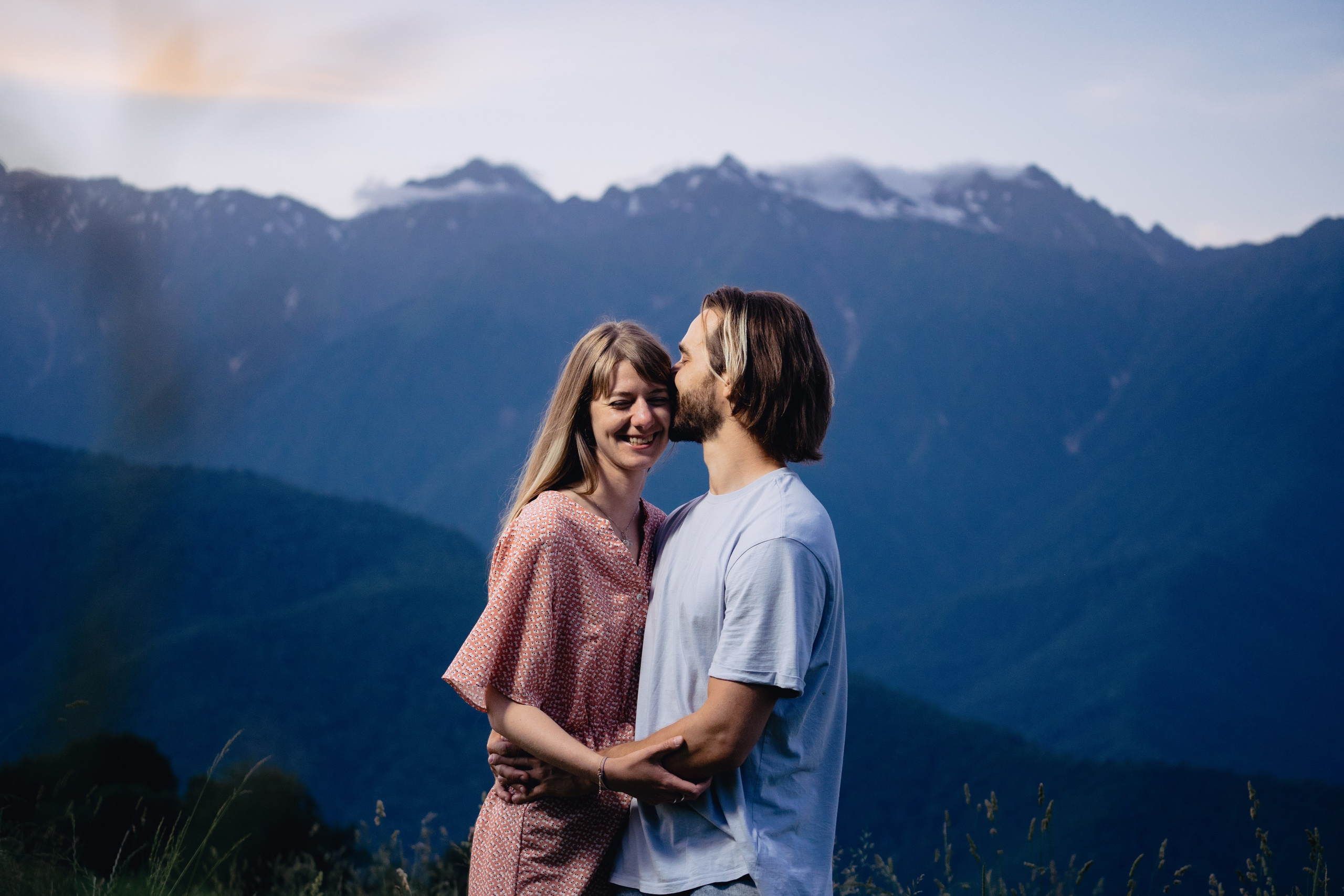 Кадр пары танцующей на закате рядом с горами