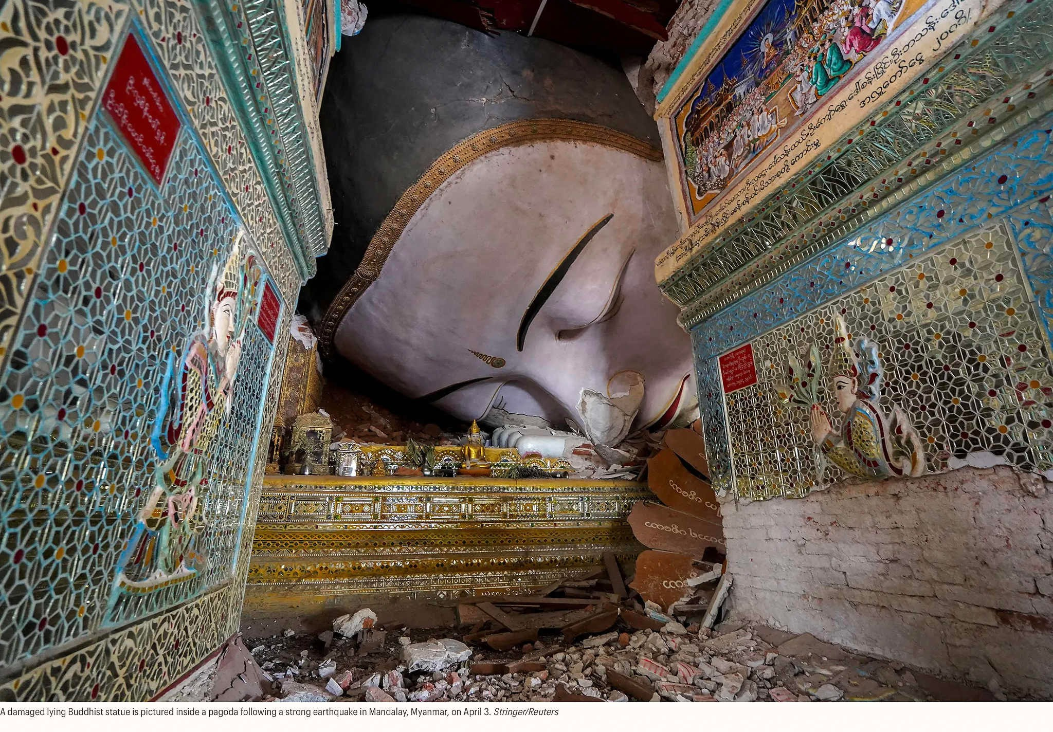 Повреждённая лежащая буддийская статуя внутри пагоды после сильного землетрясения в Мандалае, Мьянма, 3 апреля. Стрингер/Reuters