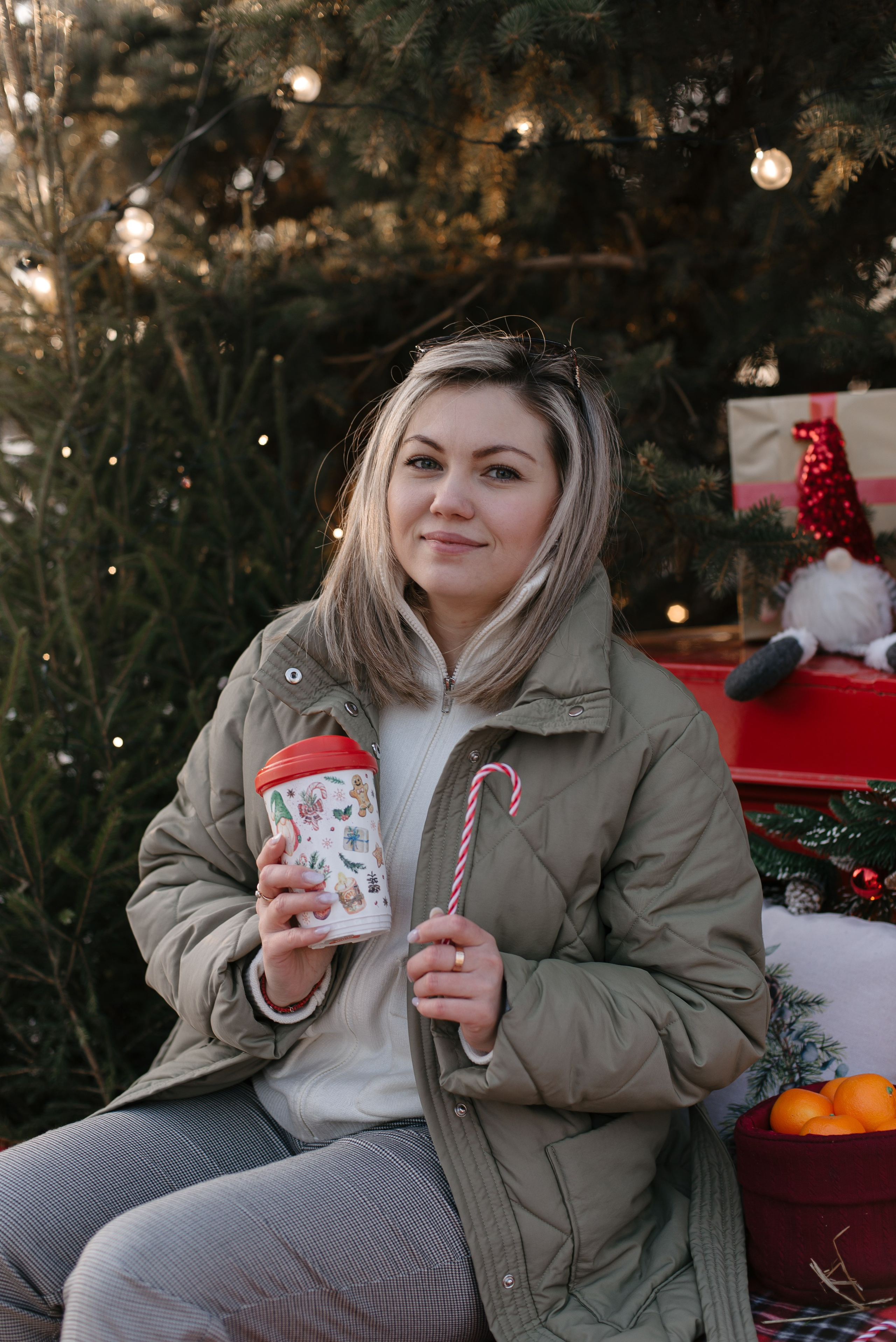 Новогодняя фотосессия: девушка с термокружкой и леденцом в парке.