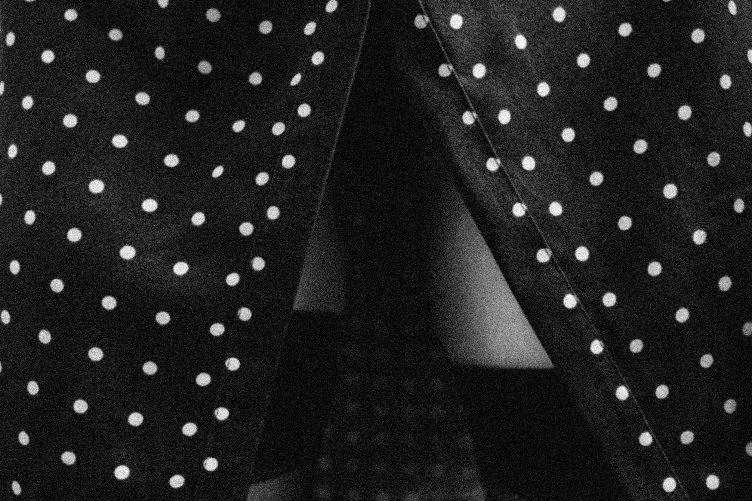 Чёрно-белое макро платья в горошек с разрезом и чулками, акцент на текстуре ткани и загадочном образе