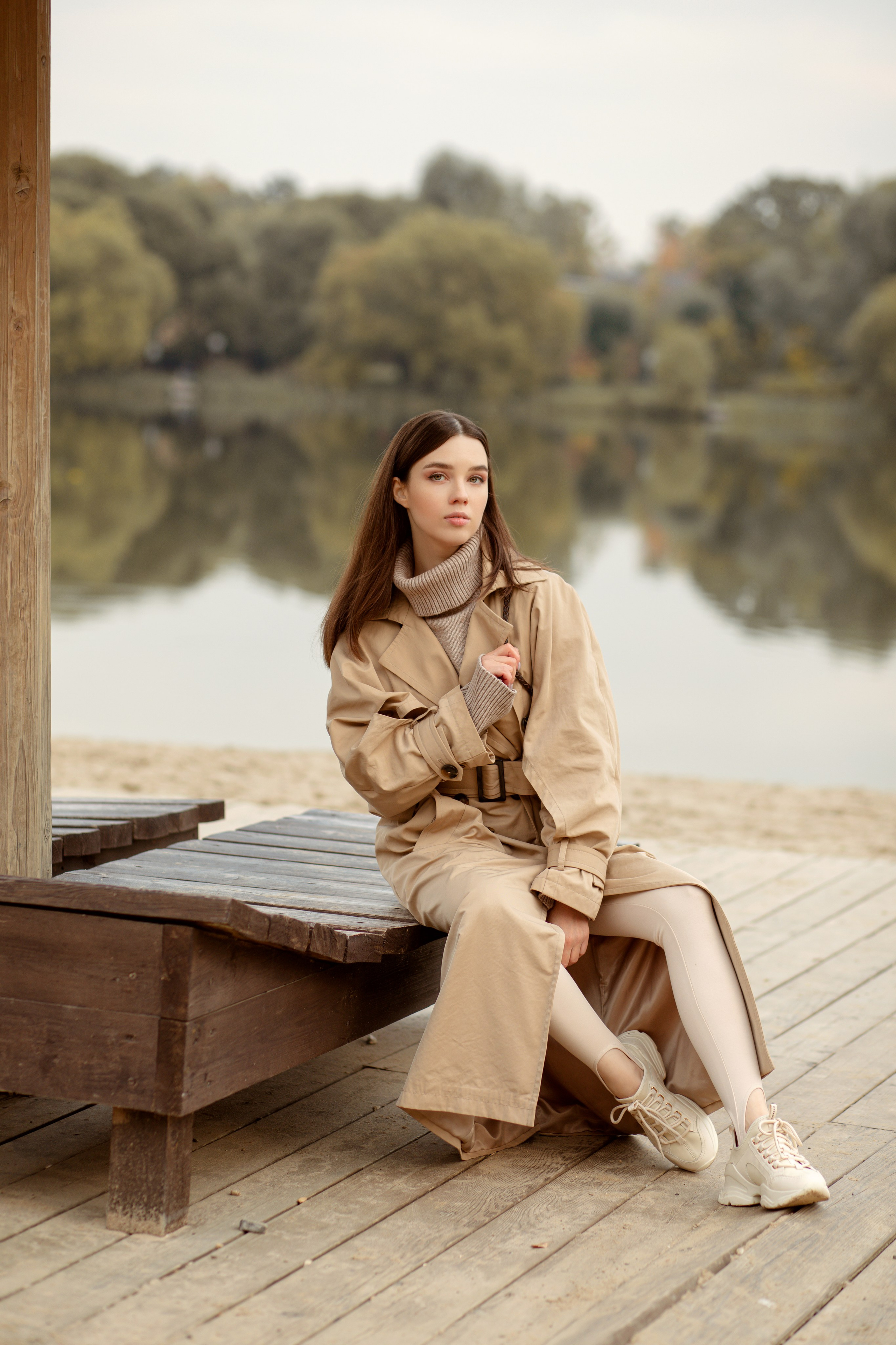 Девушка в стиле фэшен позирует у озера