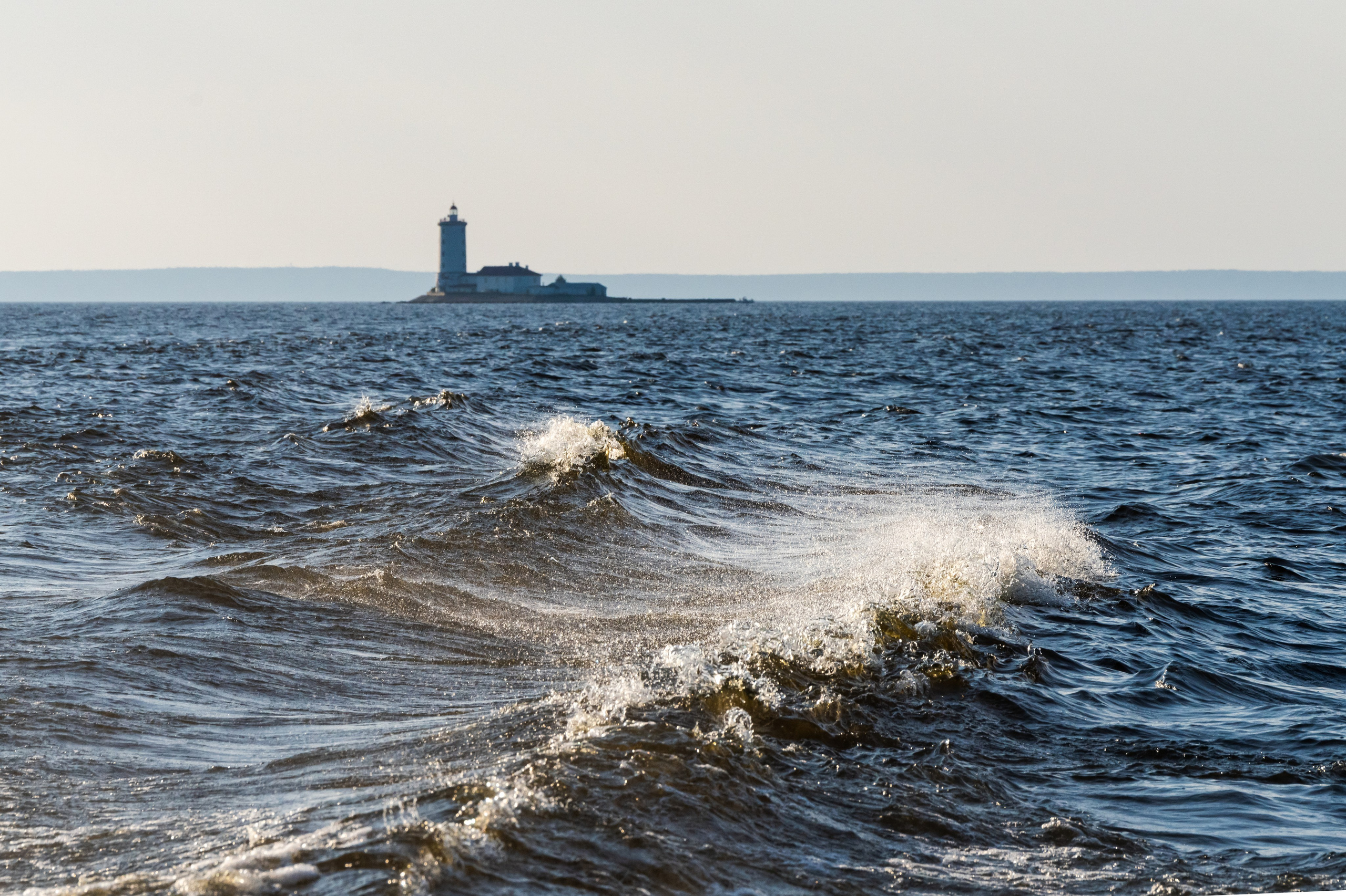 Вид на маяк Толбухин с воды на фоне больших волн