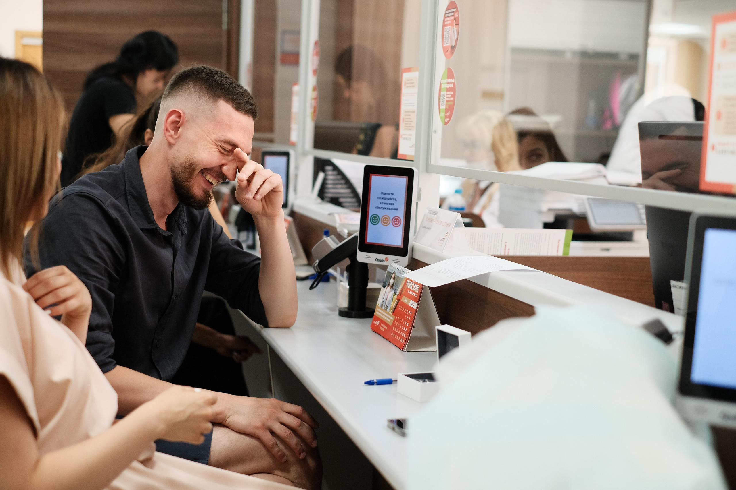 Жених смеется после подписания документов.