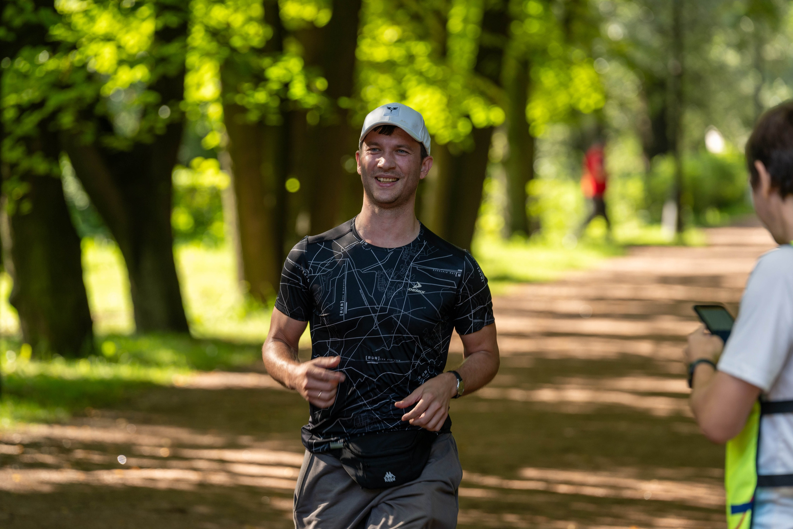 Улыбающийся участник забега «5 вёрст» в парке, спортивный фотограф Санкт-Петербург