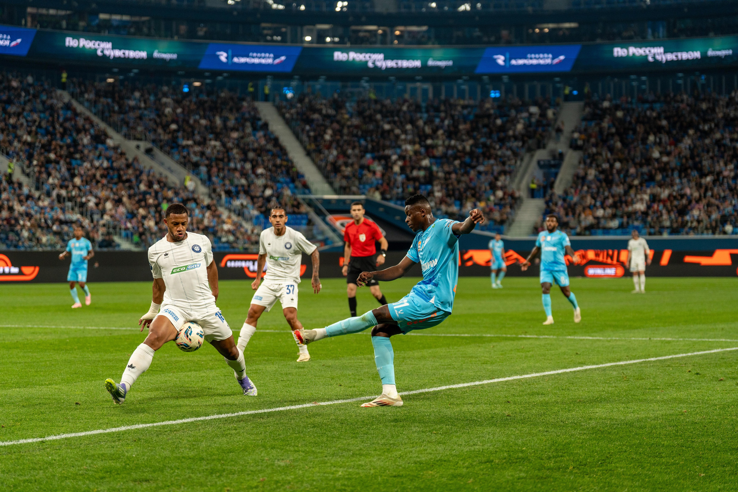 Игрок Зенита в голубой форме выбивает мяч у соперника на Газпром Арене – репортаж спортивного фотографа Санкт-Петербург