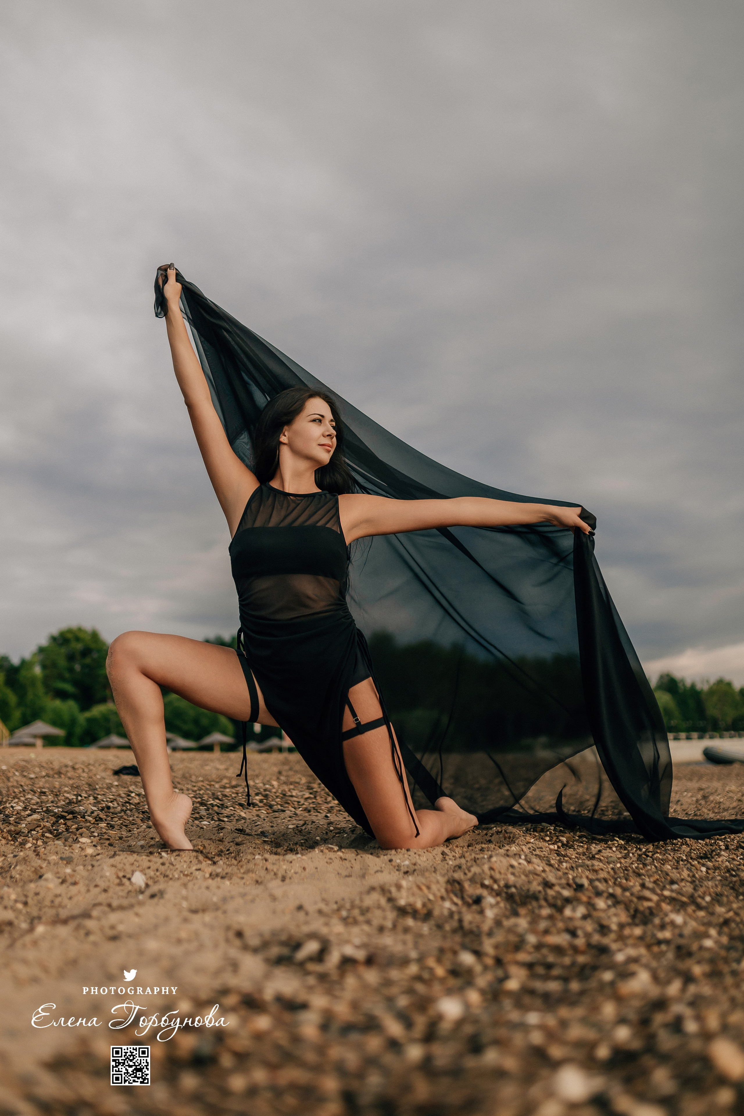 Фотосессия с черной тканью. Легкая черная вуаль летит на вертру. Фотосессия у реки черная серия с тканью. Девушка укуталась в черную ткань. Прогулка по набережной. Песок, речка, модель в черном. Качели над водой, Закат. Девушка лежит на песке. В зеленых деревьях