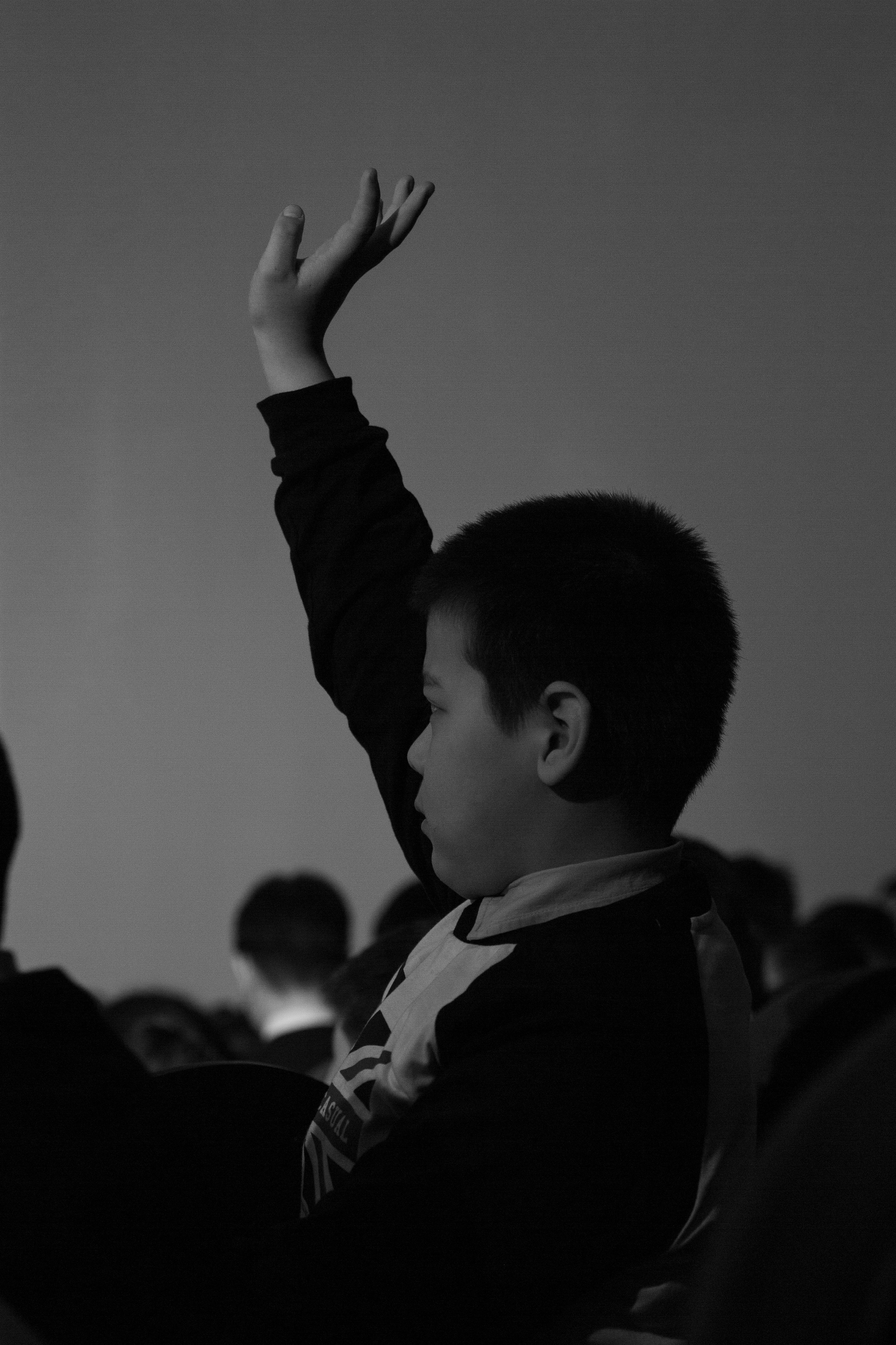 Мальчик в зале тянет руку, черно-белый стиль фотографии.