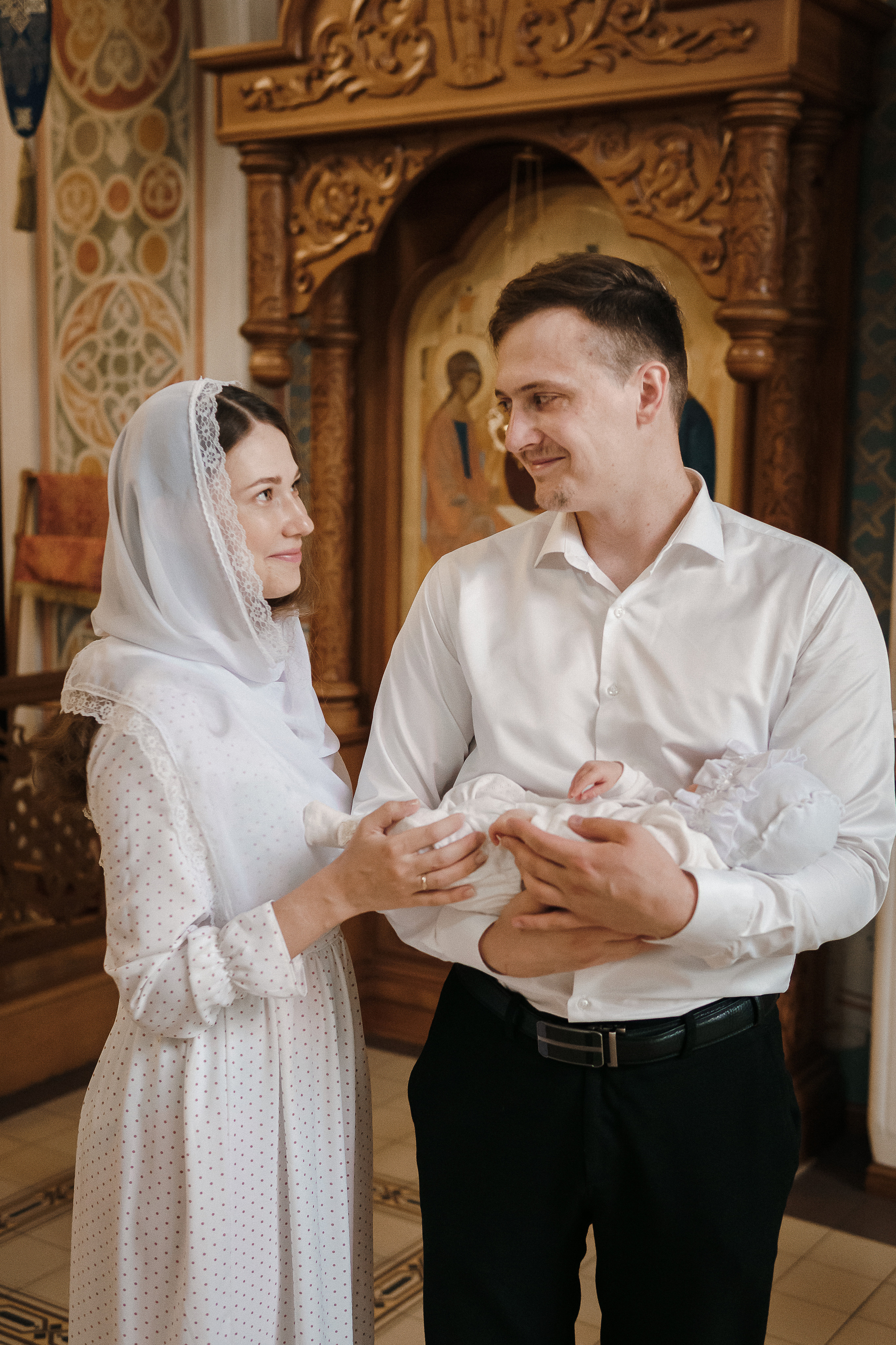 Муж и жена держат ребенка после крещения. Фотосессия таинства крещения в Воронеже. Что подарить на крещение