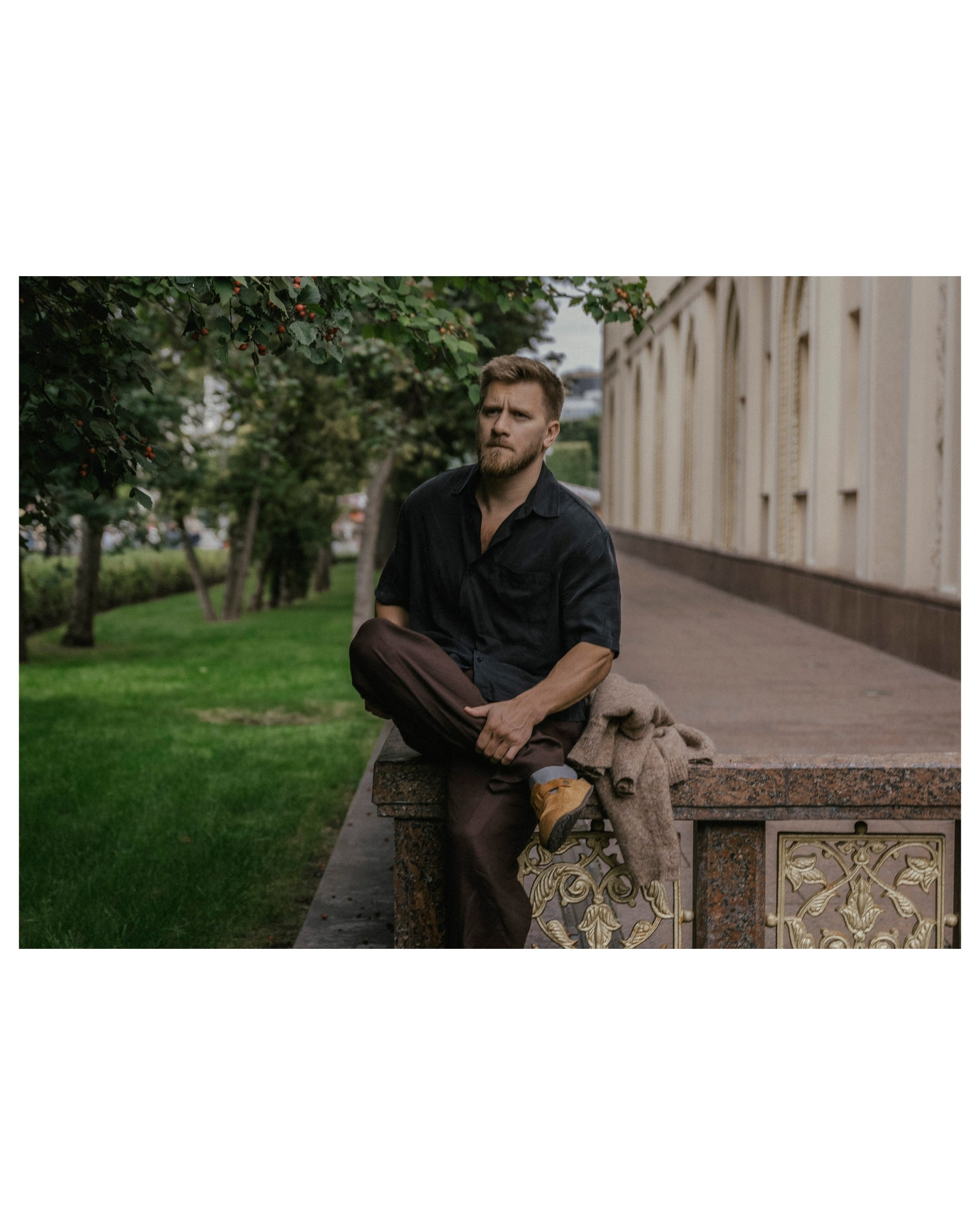 мужчина в льняном костюме сидит нога на ногу