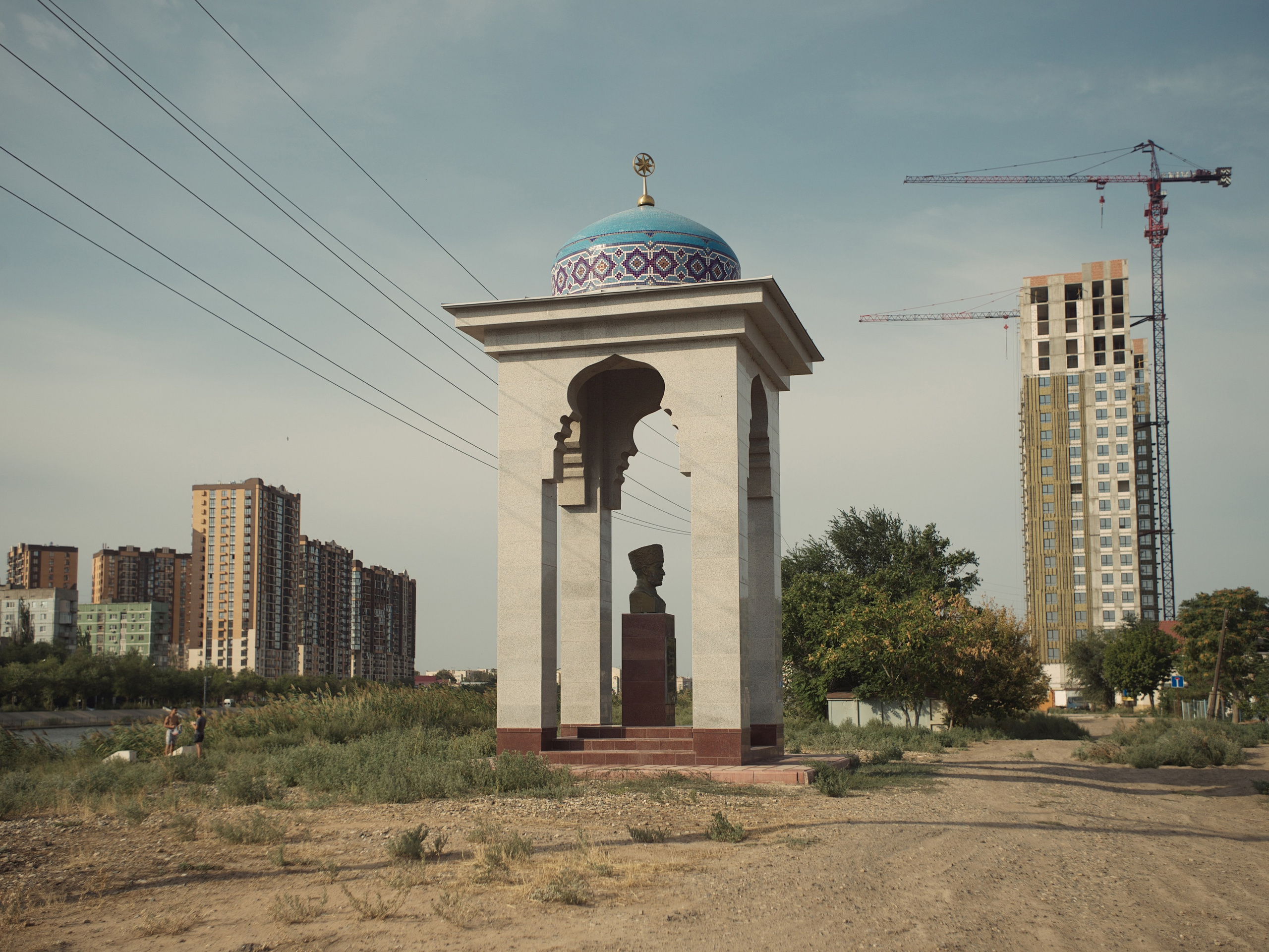 Bust of Nogai people educator Abdulhamid Dzhanibekov and new buildings emerging on the site of the old Tatar district