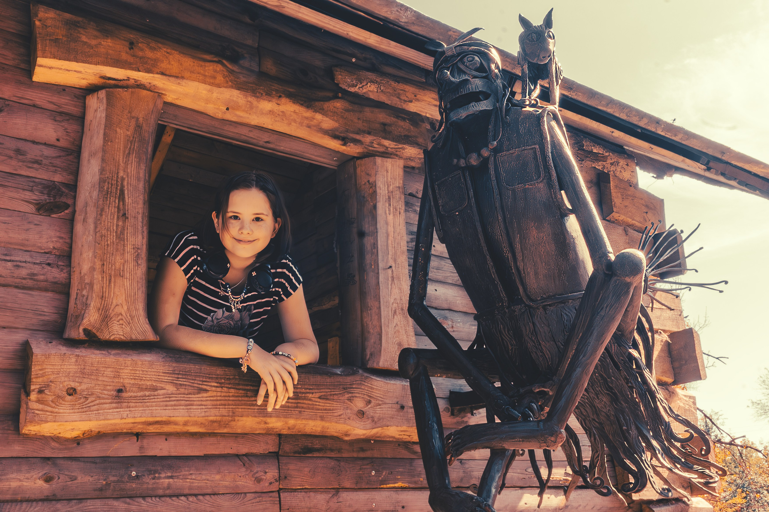 Девочка смотрит из окна избушки на курьих ножках