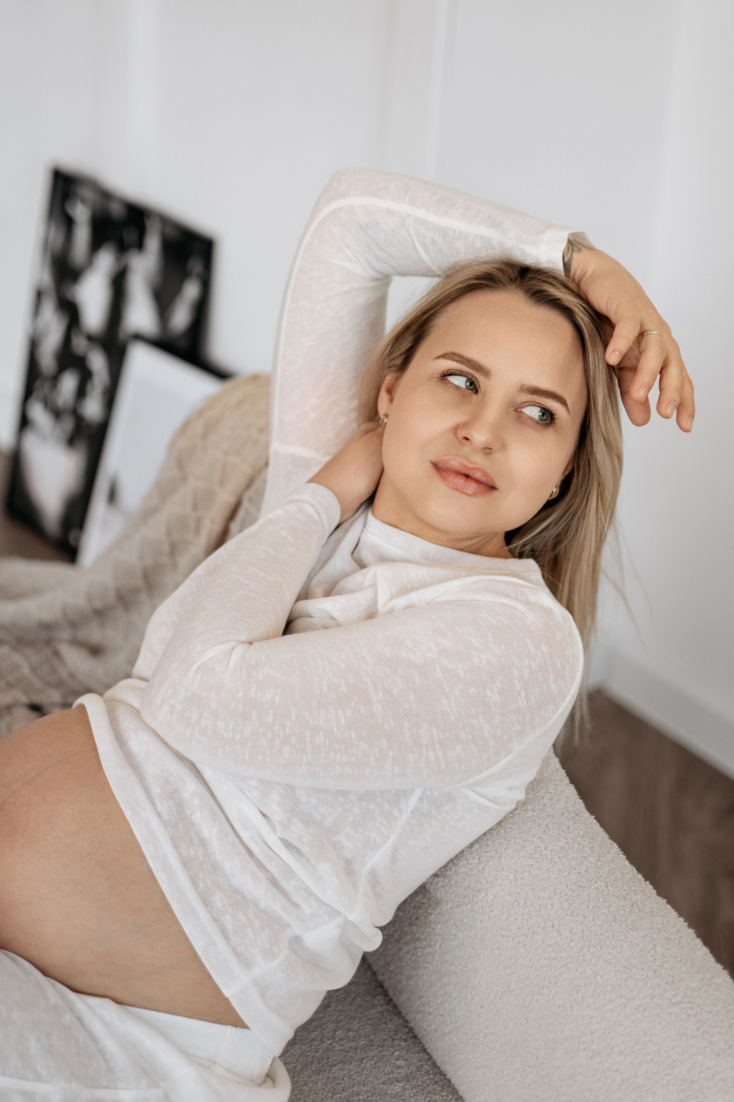 Сольный портрет беременной: умиротворенная улыбка будущей мамы, руки нежно лежат на животе, на котором играет солнечный свет.