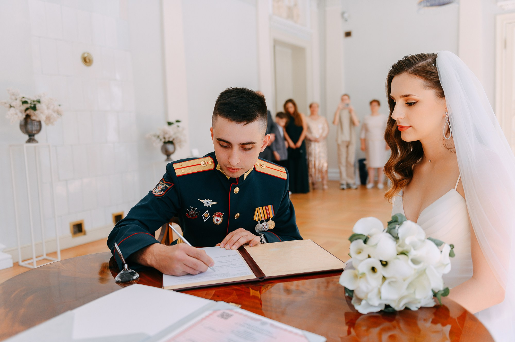 Жених ставит подпись в свидетельстве в загсе.