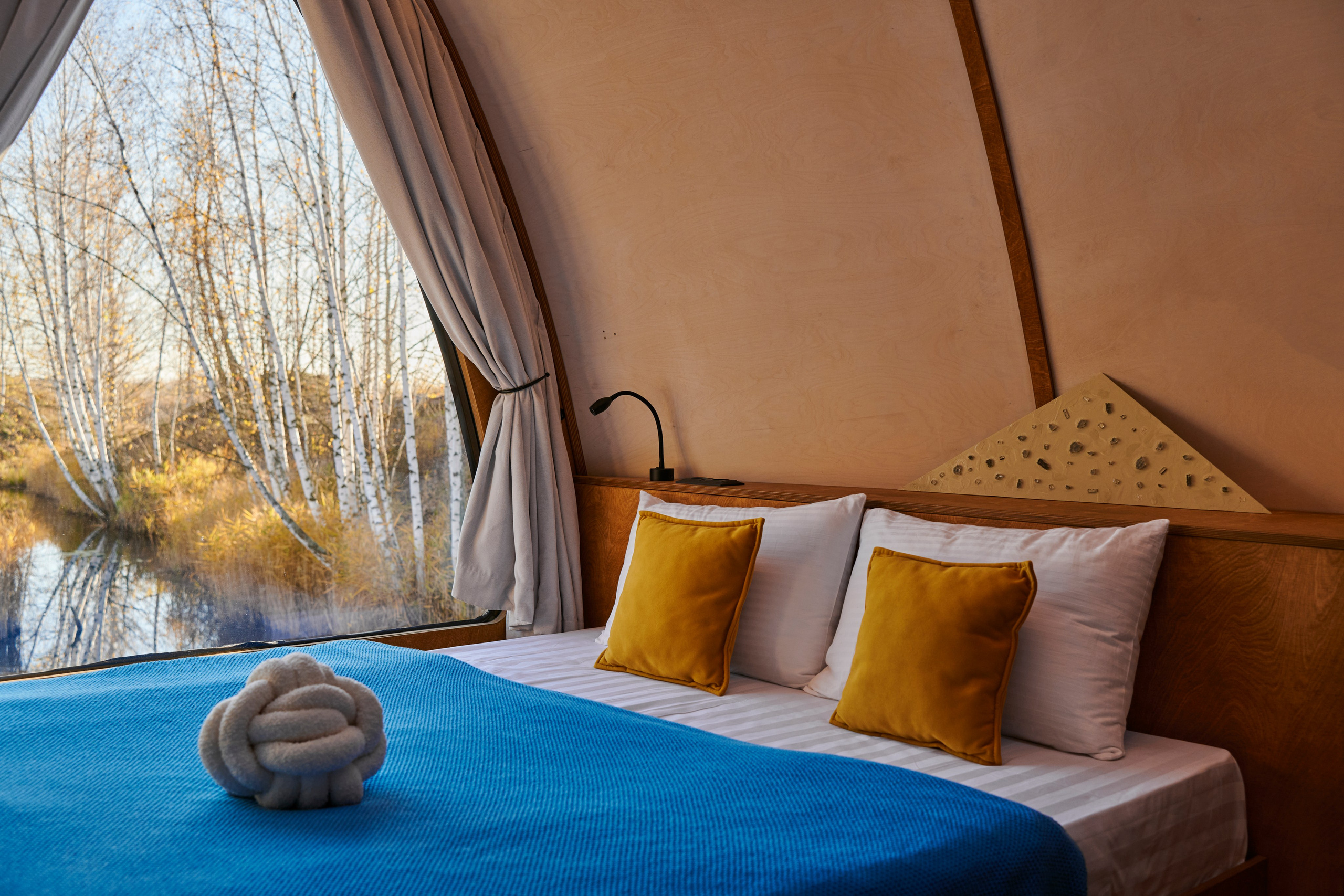 Уютный шатёр, двуспальная кровать и подушки, тёплый цвет.