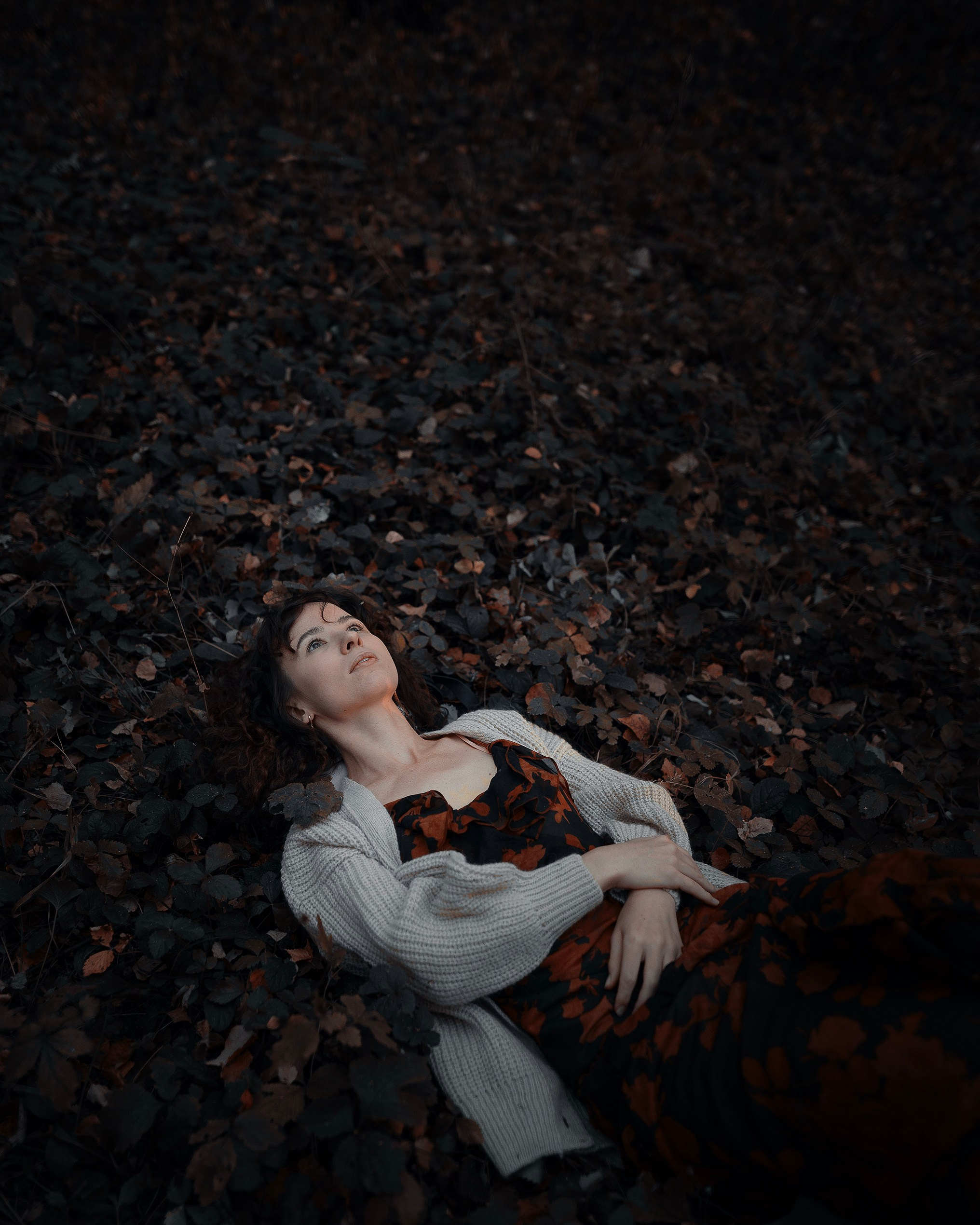 Девушка в светлом пальто стоит на золотой осени 