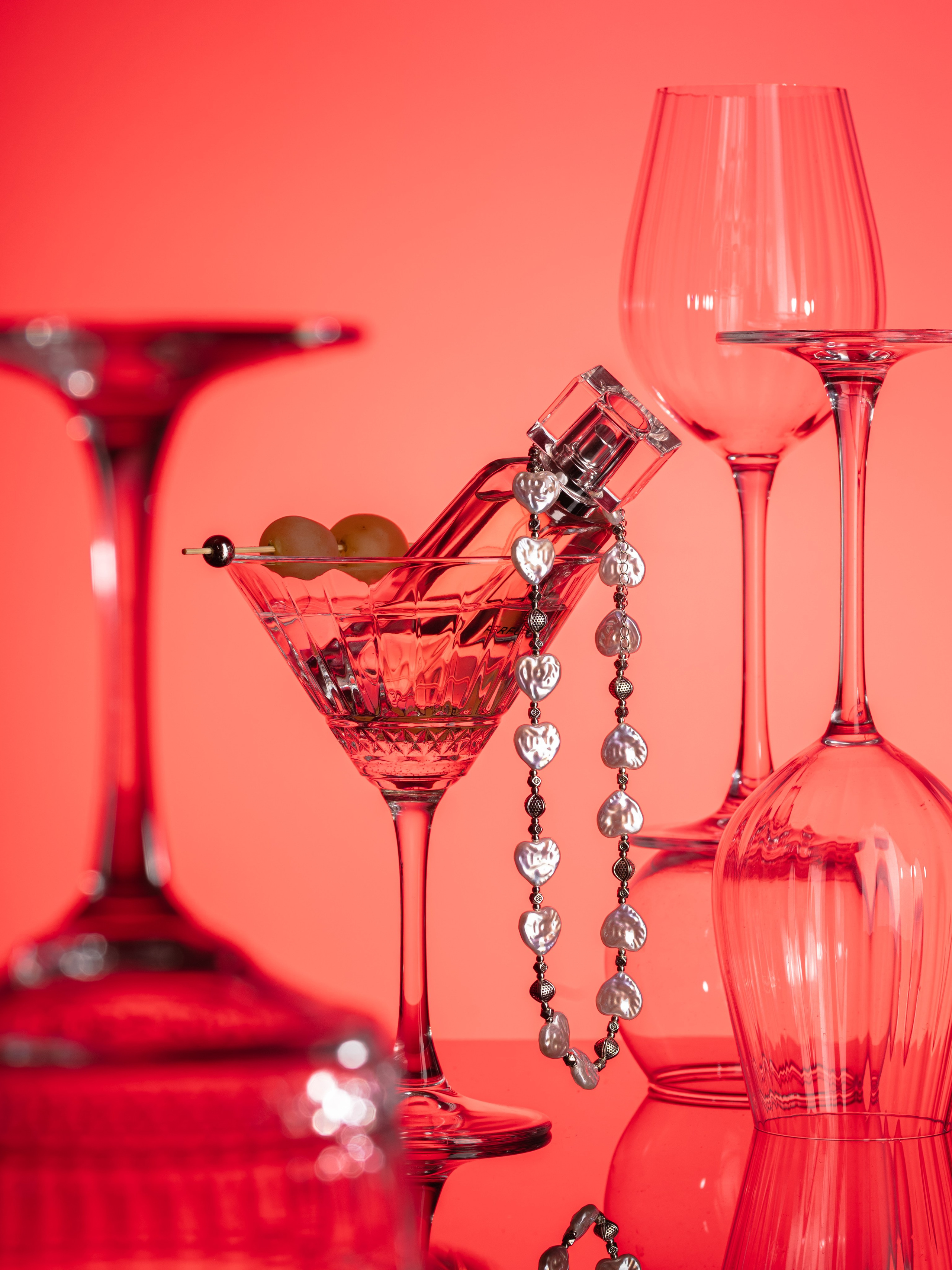 будуарный стиль жемчужное ожерелье в бокале с мартини на прозрачном цветном фоне