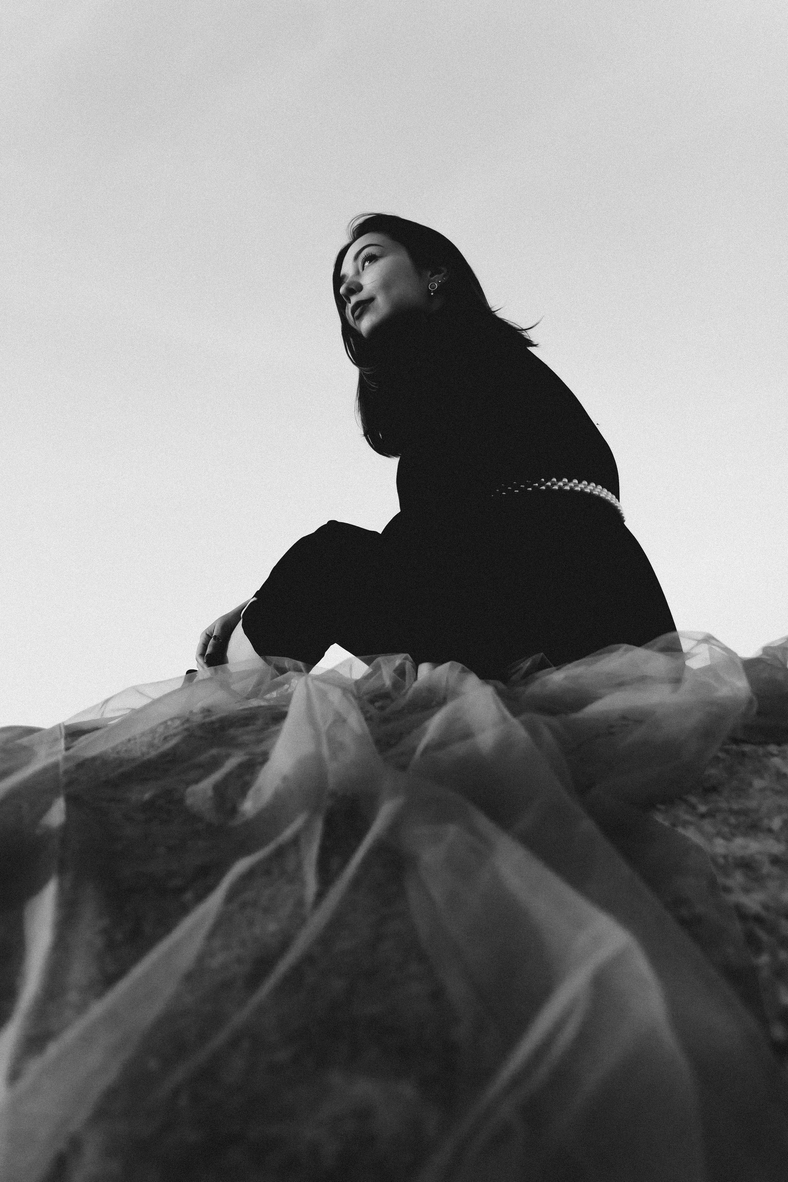 Черно белая фотография девушки, сидящей на ткани