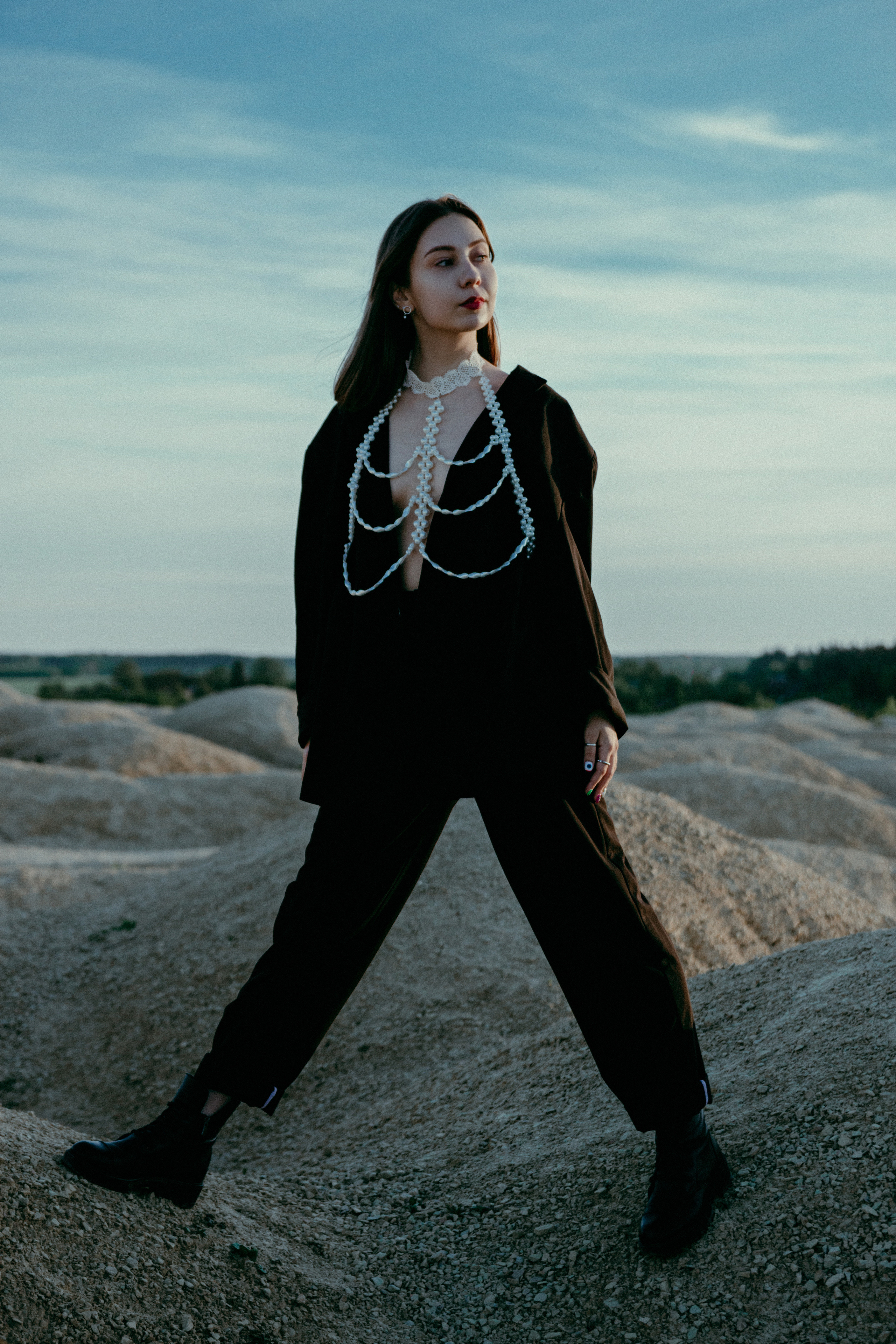 Стильная фотография девушки в черном костюме на фоне карьера